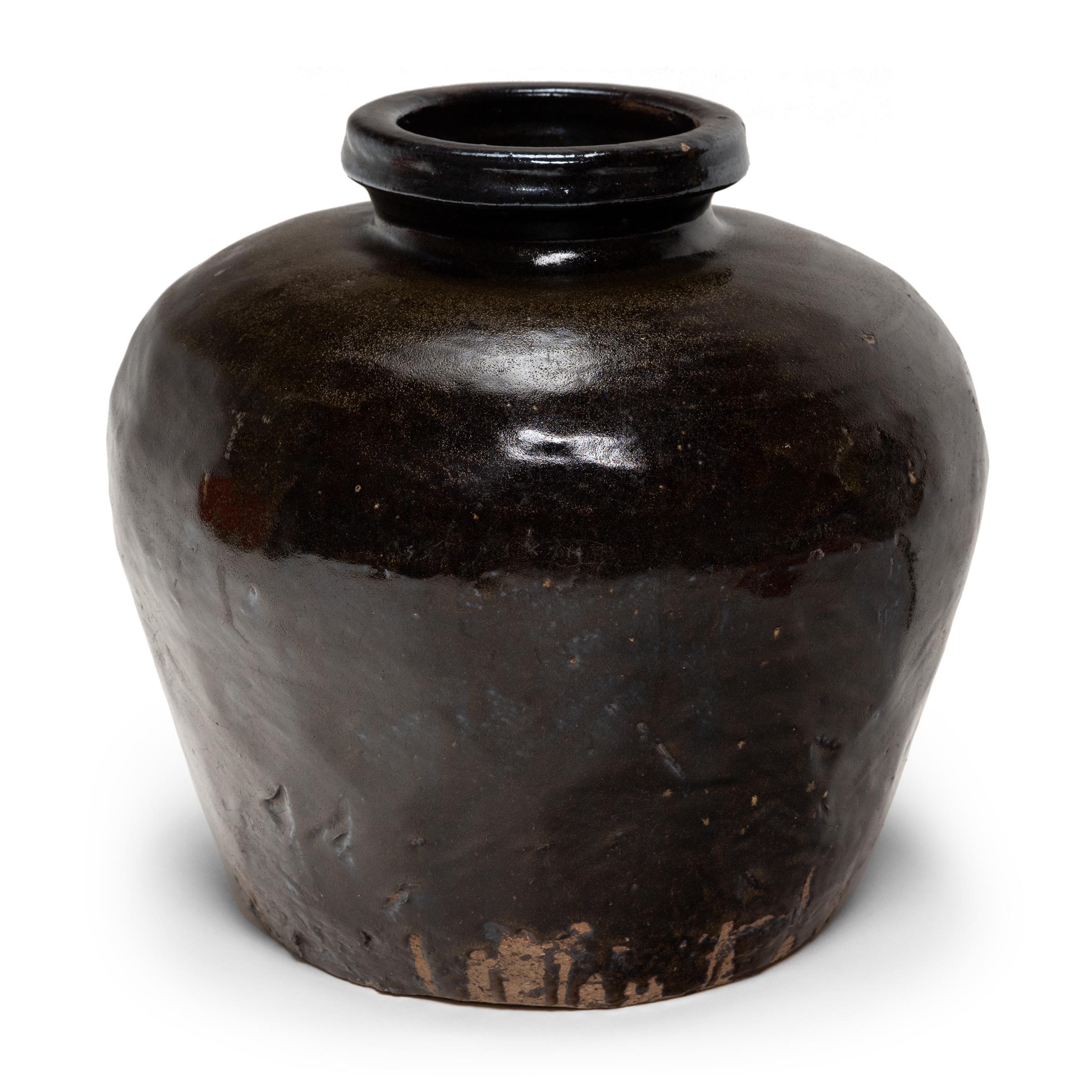 Utilizada originalmente para fermentar arroz o sorgo y convertirlo en vino o vinagre, esta vasija de barro de principios del siglo XX está recubierta por dentro y por fuera de un grueso vidriado oscuro. El rico vidriado marrón se extiende y acumula