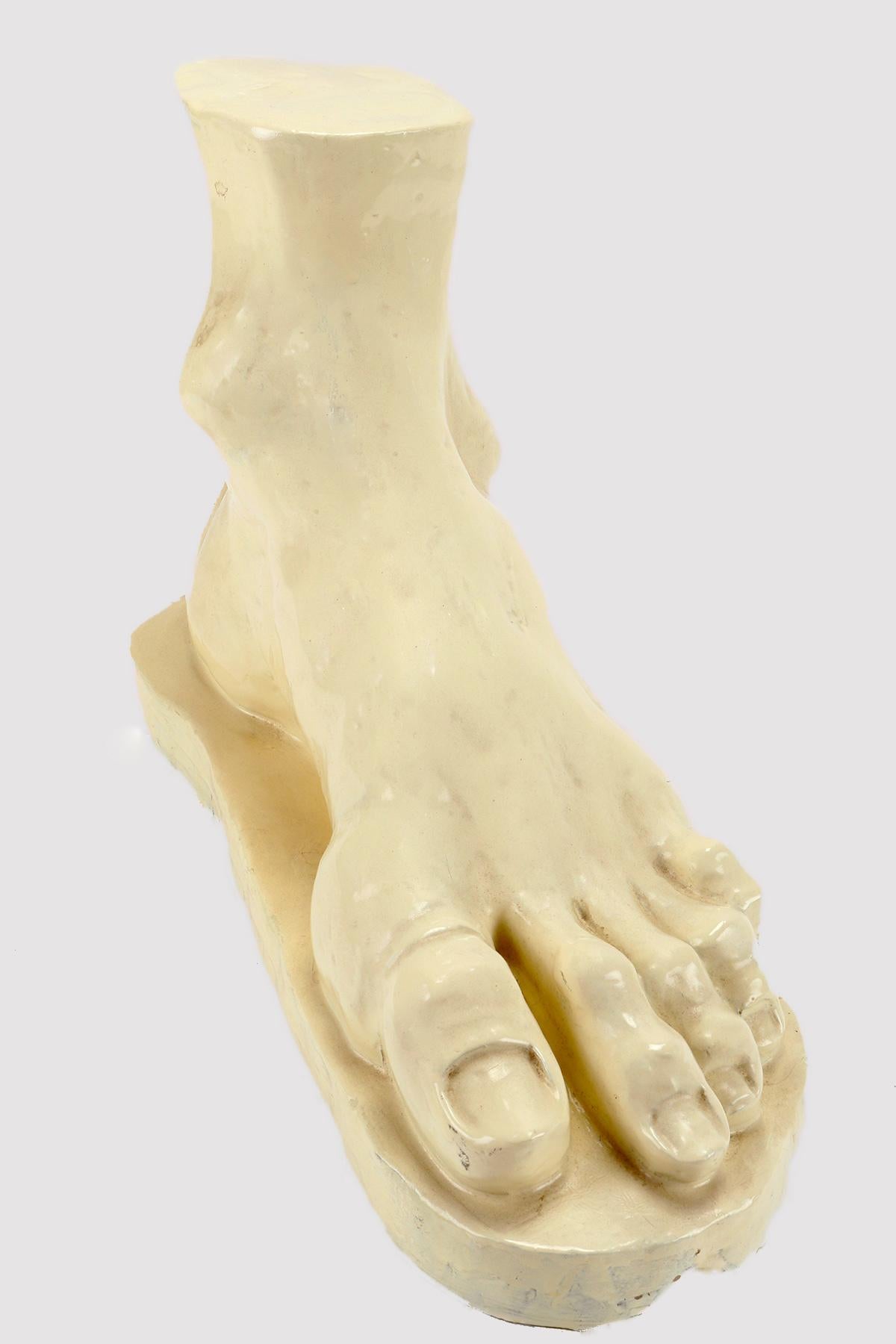 Sculpture in gray terracotta glazed in white, depicting a foot. The sculpture is obtained by gradually adding individual terracotta elements by hand. The foot is an example of sculptural excellence in both movement and detail. The sculpture is