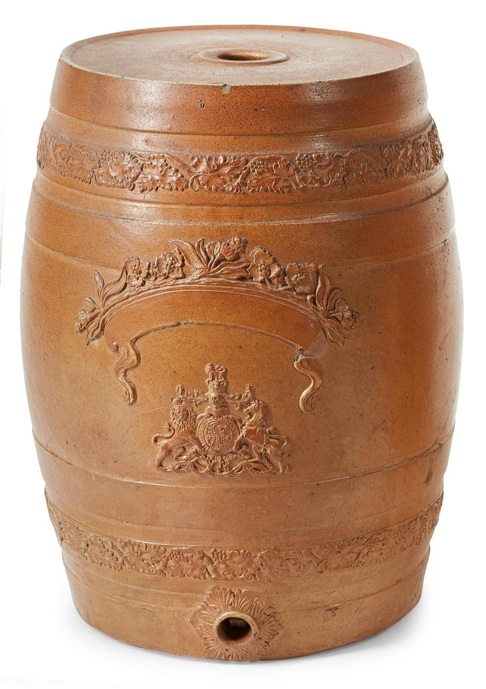 A pair of glazed ironstone barrels in attractive soft umber tones with finely cast foliate decoration and bearing the British seal of the imperial realm. Originally gin barrels. Now suitable as drinks tables or for rewiring as lamps.  England, circa