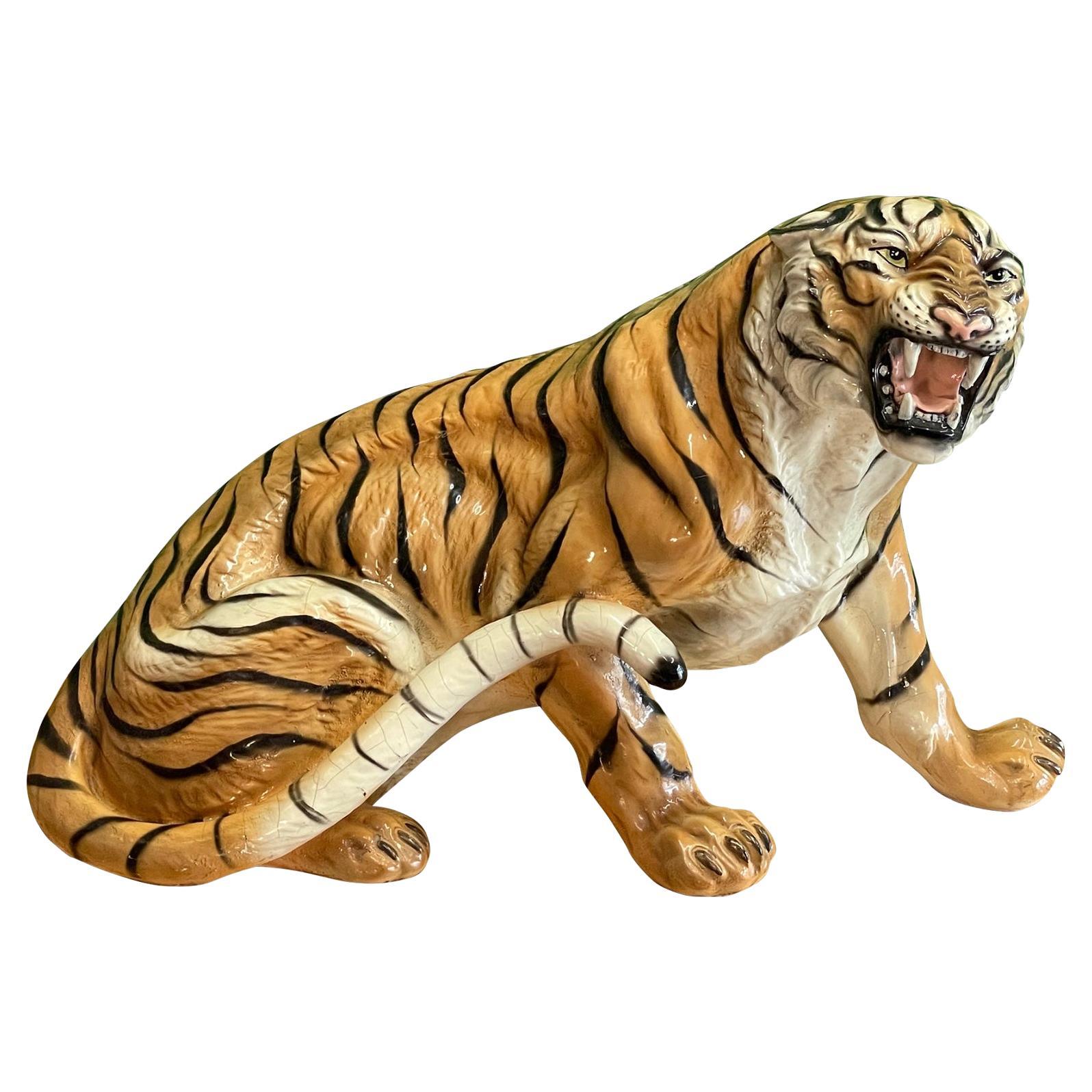 Large terracotta tiger sculpture features a menacing stance and a bright glazed finish. Good condition with imperfections consistent with age, including a few hairline cracks but not affecting the structural integrity of the piece. See photos for