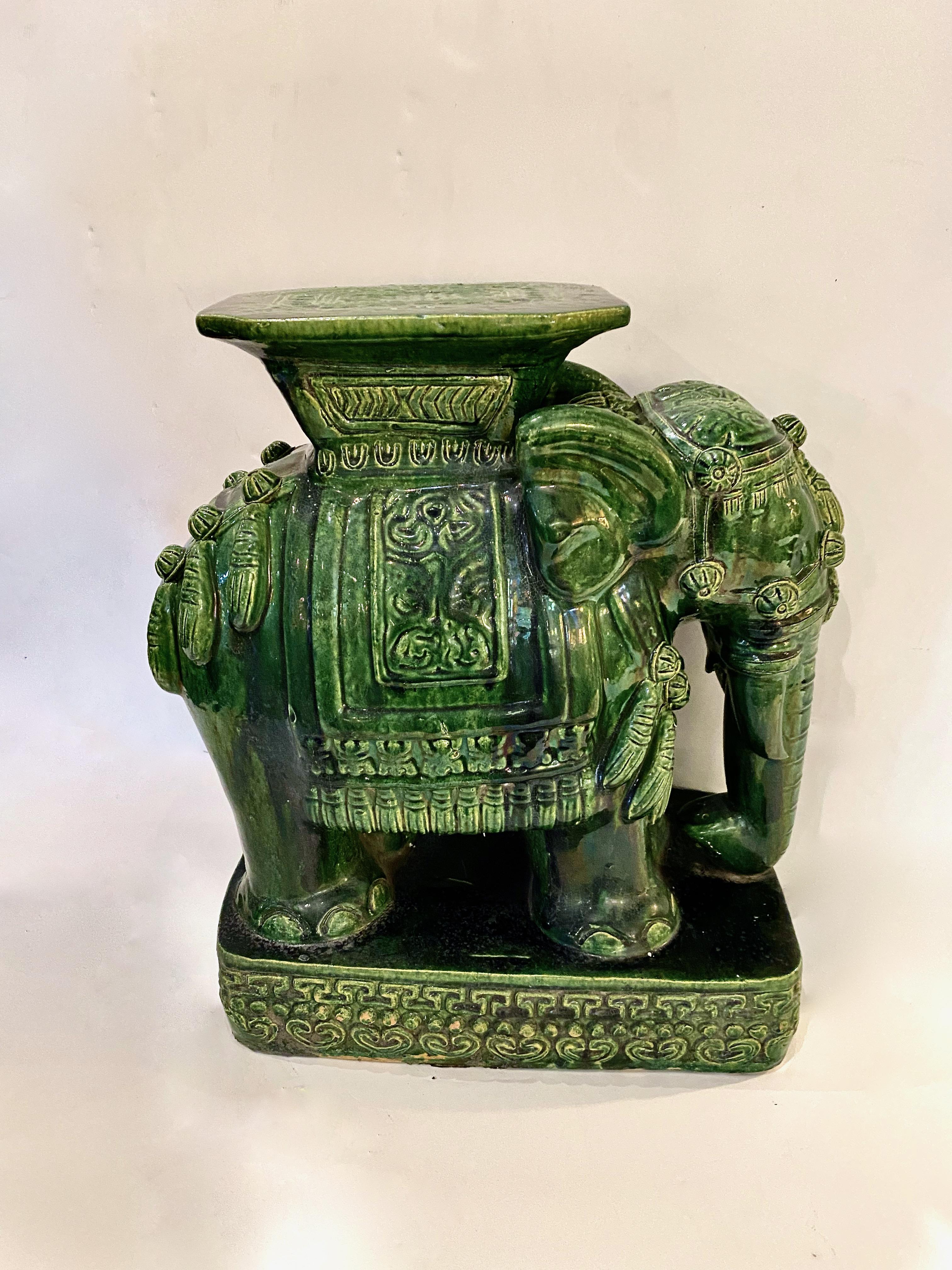This is a very good example of a mid-century Asian glazed terracotta elephant garden seat or table. The stunning thick green glaze of the elephant makes him unusual and desirable. The beautiful detailing of the tassels is highlighted by the thick