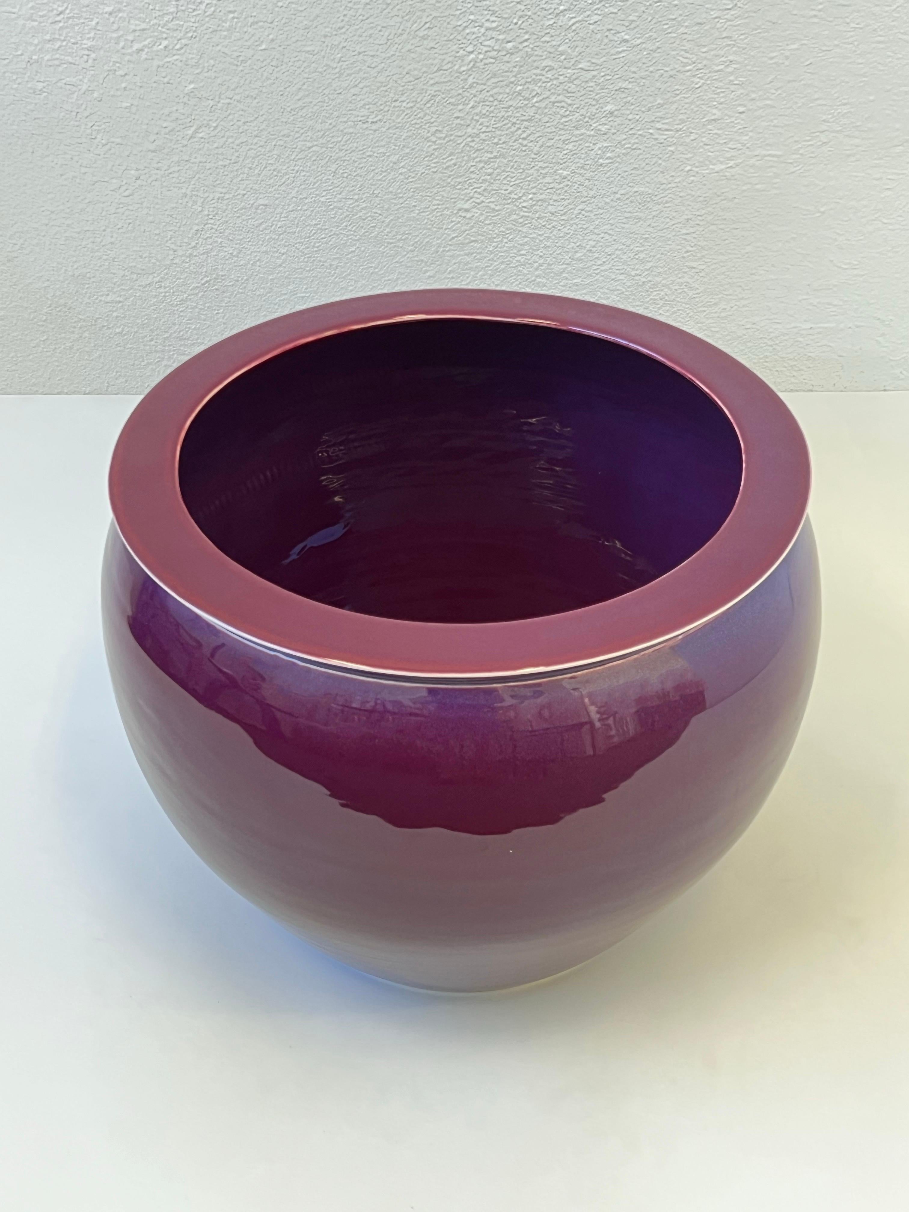 Rare burgundy purple glazed porcelain planter by renowned designer Karl Springer. 
In beautiful vintage condition, with minor wear consistent with age( see detail photos).

Measurements: 22” Diameter, 17” High.”