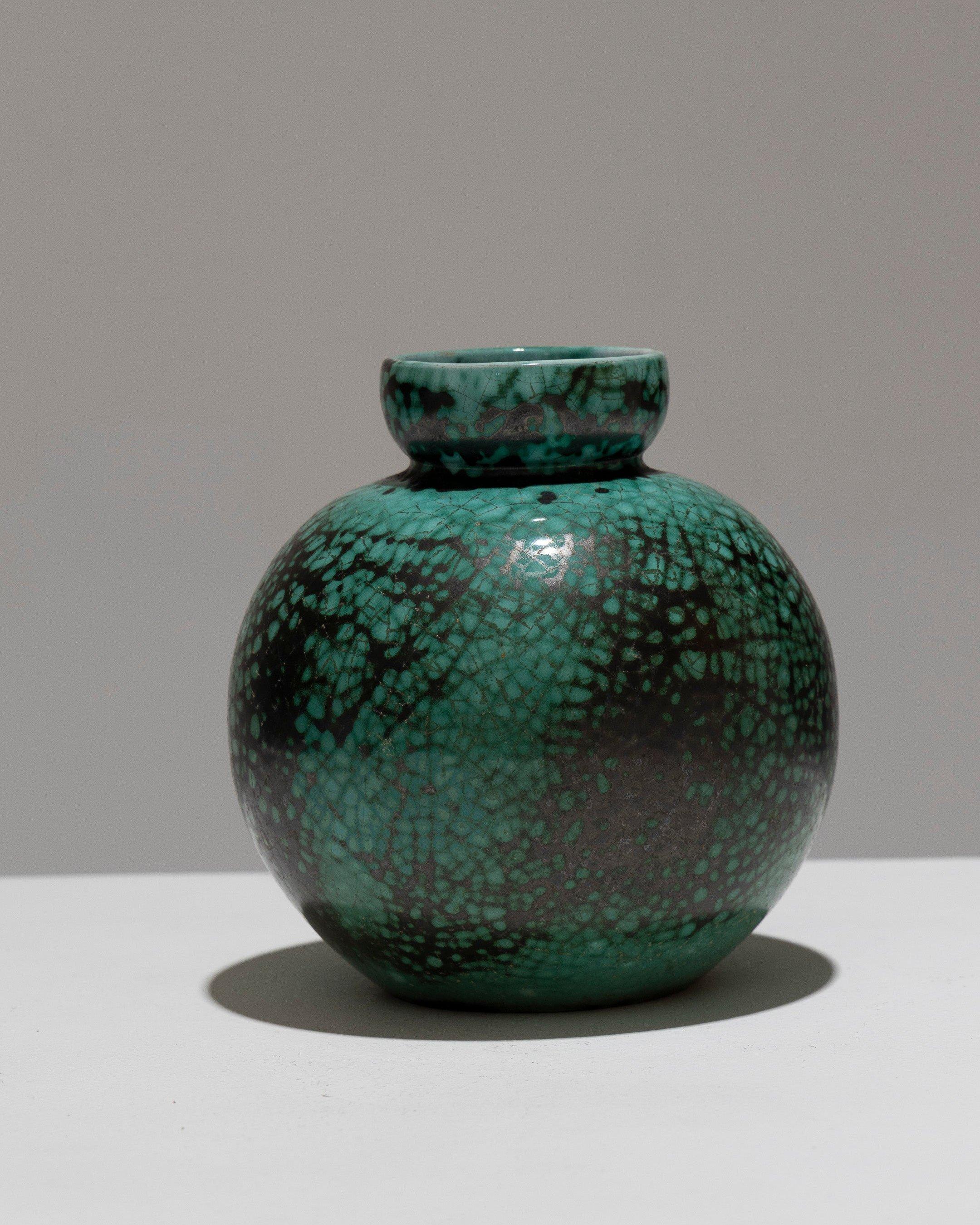 Vaso a sfera in ceramica smaltata, prodotto da CAB per Primavera, anni '30. Presenta un collo stretto e curvo verso l'interno con uno smalto verde smeraldo screpolato e un sottile motivo di venature verde scuro e nero. Firmato sotto la base: