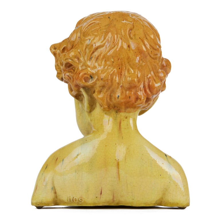 A stunning antique continental, probably French, glazed art pottery bust of a child in the manner of renowned French sculptor Jean Marie Camus (1877-1955). The hollow and lightly potted bust is finely made with excellent detail with the child