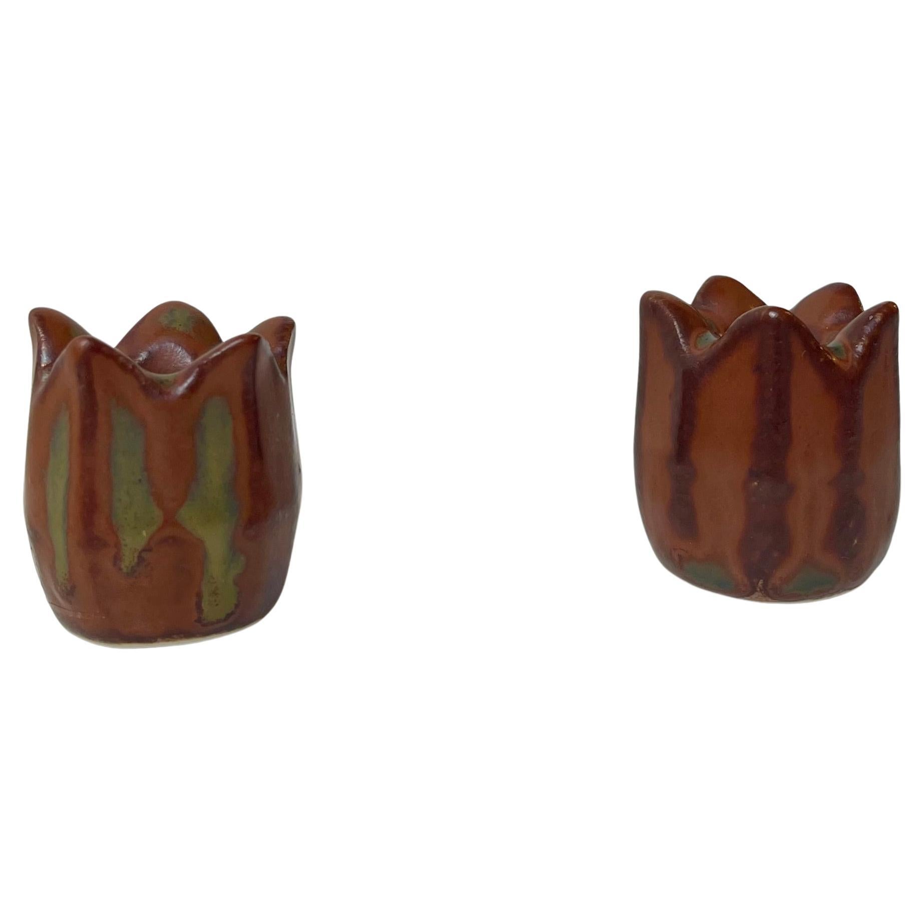 Piccolo candeliere a forma di bocciolo di rosa in gres smaltato dell'icona della ceramica Eva Stæhr Nielsen. Eseguito con sfumature rosse e verdi. Prodotto da Saxbo in Danimarca negli anni Cinquanta. Condizioni perfette. Su entrambi i pezzi sono