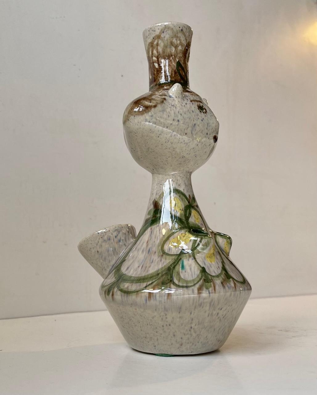 A Picasso inspired stoneware vase in the shape of a female figurine. Its a unique piece and was executed by the Danish artist, sculptor and ceramist Paul Nyhuus (1911-70) during the 1960s. It has a distinct naive styling and features 4 holes for