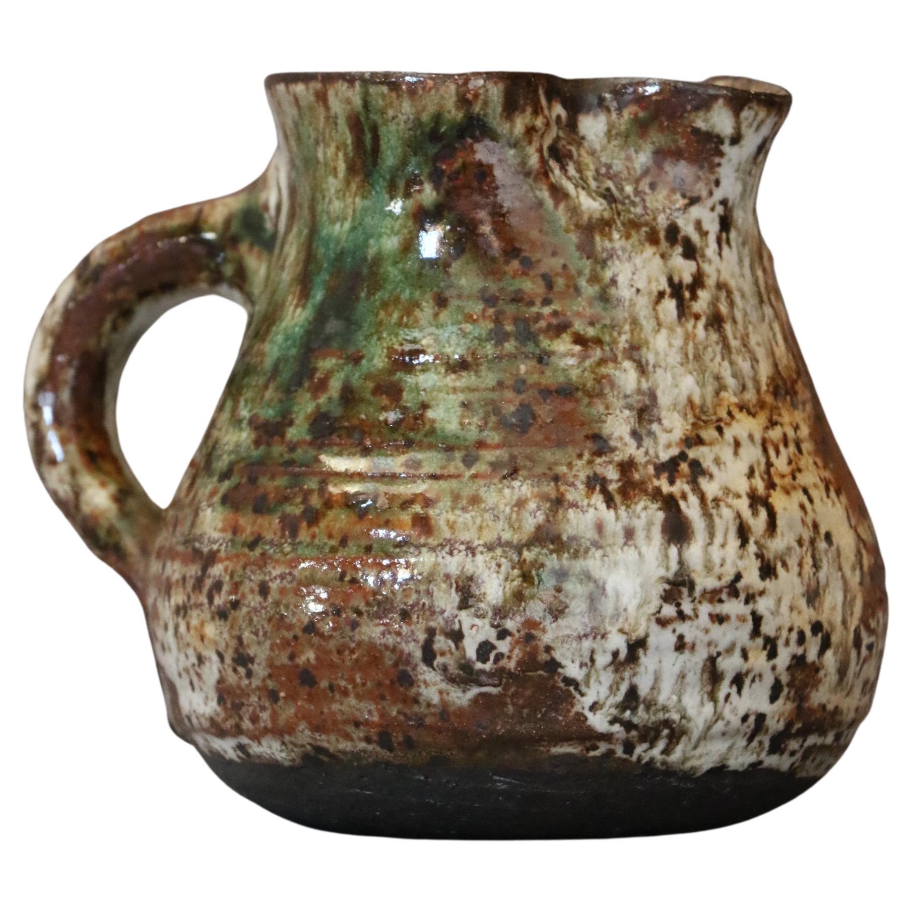 Glazed stoneware zoomorphic pitcher by Cécile Dein, circa 1960. Signed. 

Stoneware pitcher in the shape of an owl glazed in brown and dark green tones. In the style of la Borne pottery. 
Signed on the bottom. The piece is in very good