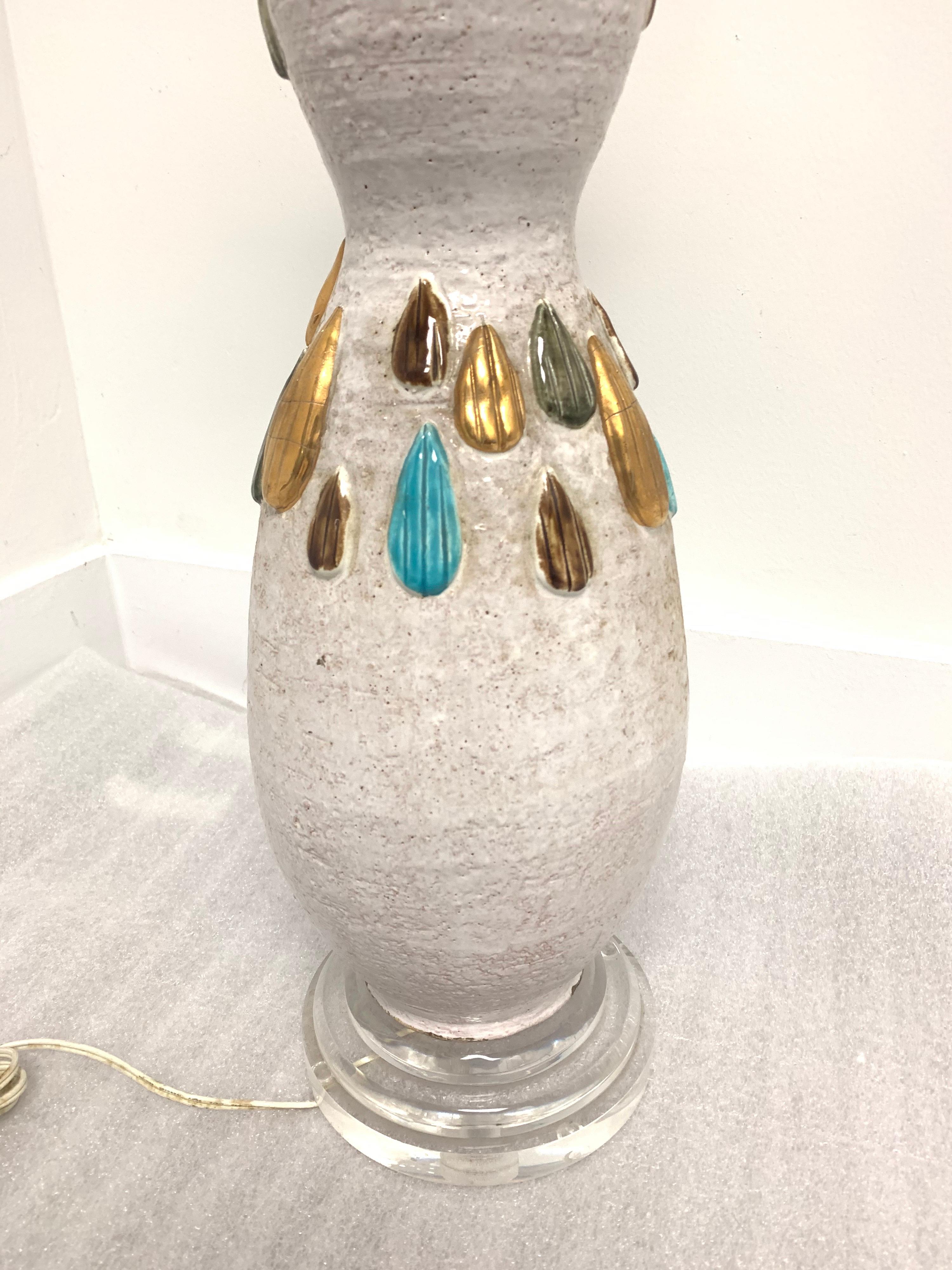 Tall glazed earthenware lamp with tear drop relief in jewel tones.