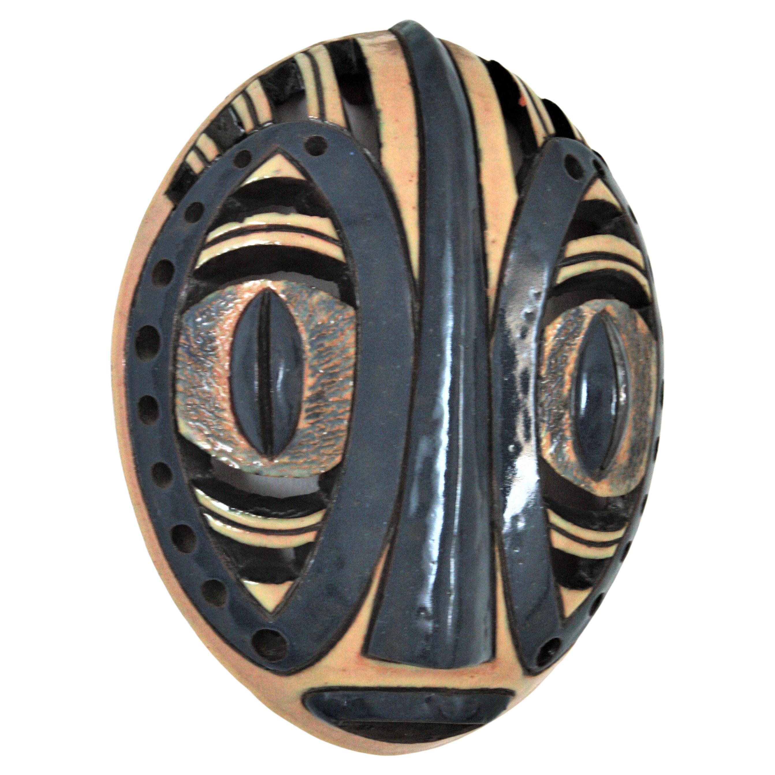 Dekorative afrikanische Stammesmaske aus blauem und cremefarbenem glasiertem Terrakotta, 1970er Jahre
Cool als Wanddekoration.
Materialien: Terrakotta, glasiert
Farben: Beige, Blau
Maße: 32 cm H x 24 cm B x 9 cm T // 12,59 in H x 9,44 in B x