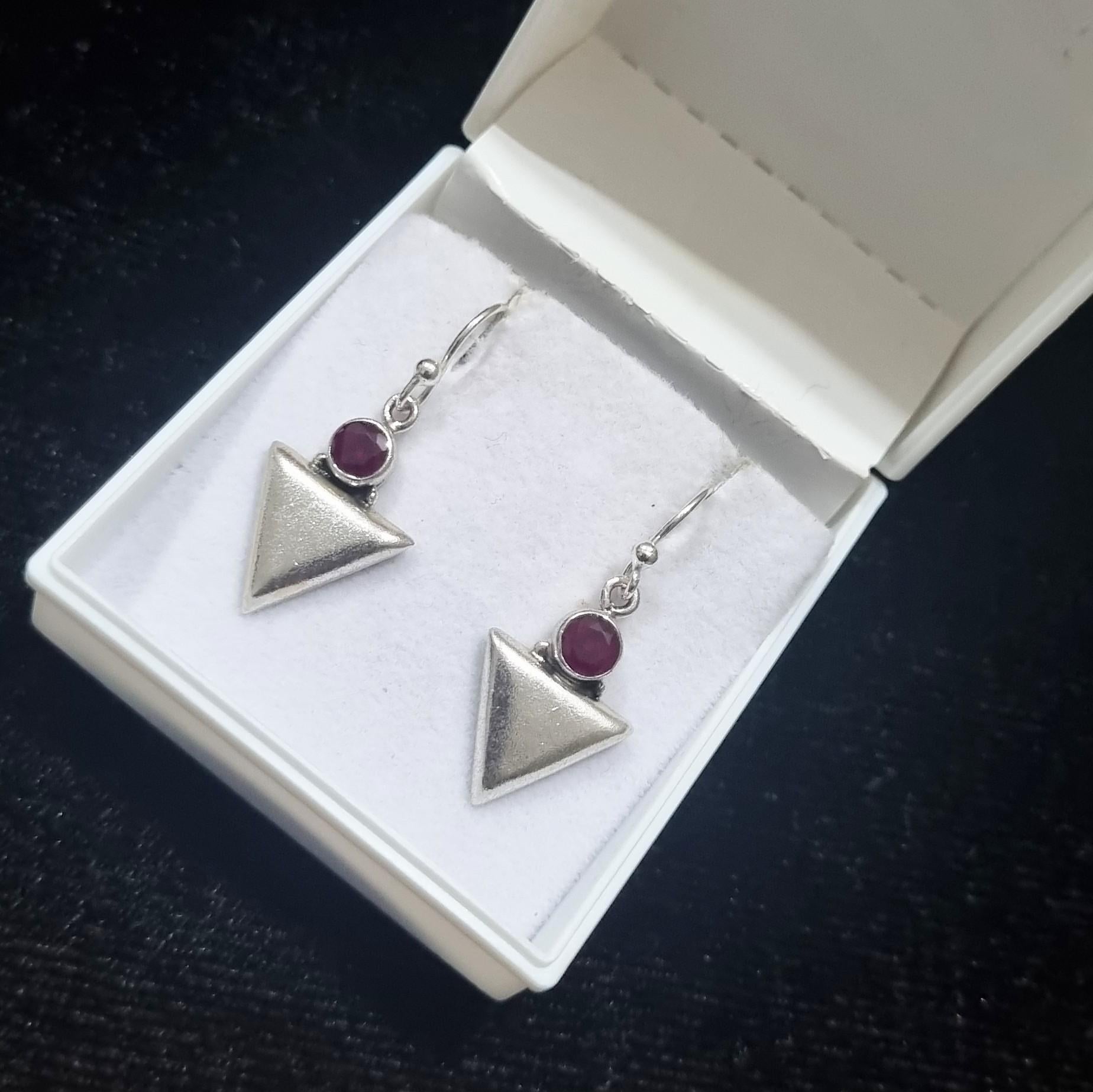 Elevate your style with these exquisite dangle sterling silver earrings adorned with mesmerizing round garnet gemstones. Crafted with precision and elegance, these earrings exude sophistication and charm.

Each earring features a stunning round