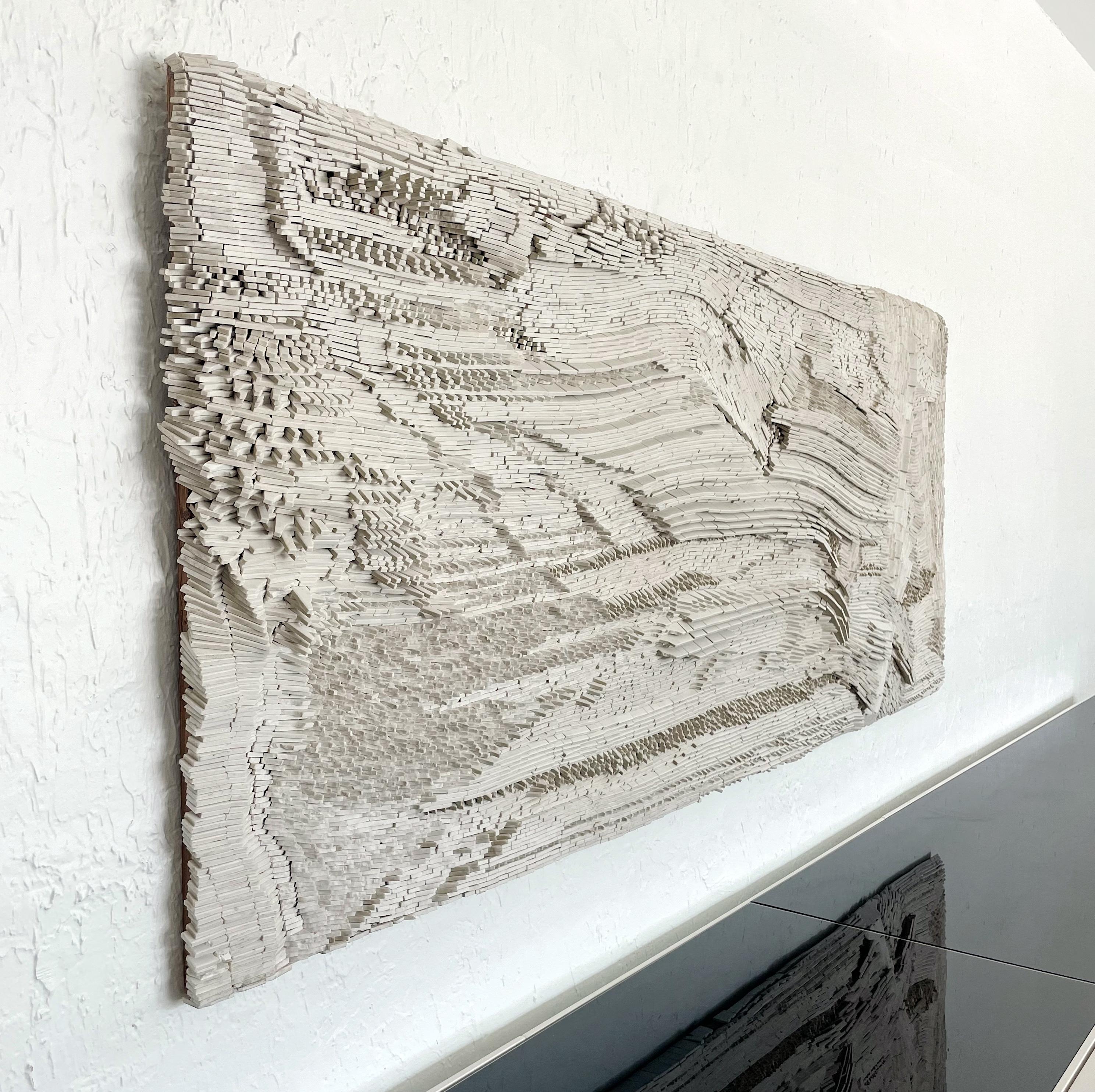 Monumental stone wall sculpture varying shades of white by Cranbrook artist Glen Michaels. Michaels was influenced by the landscape of the Pacific Northwest, His work usually featured jagged tiles that echoed these rock formations. We spoke with
