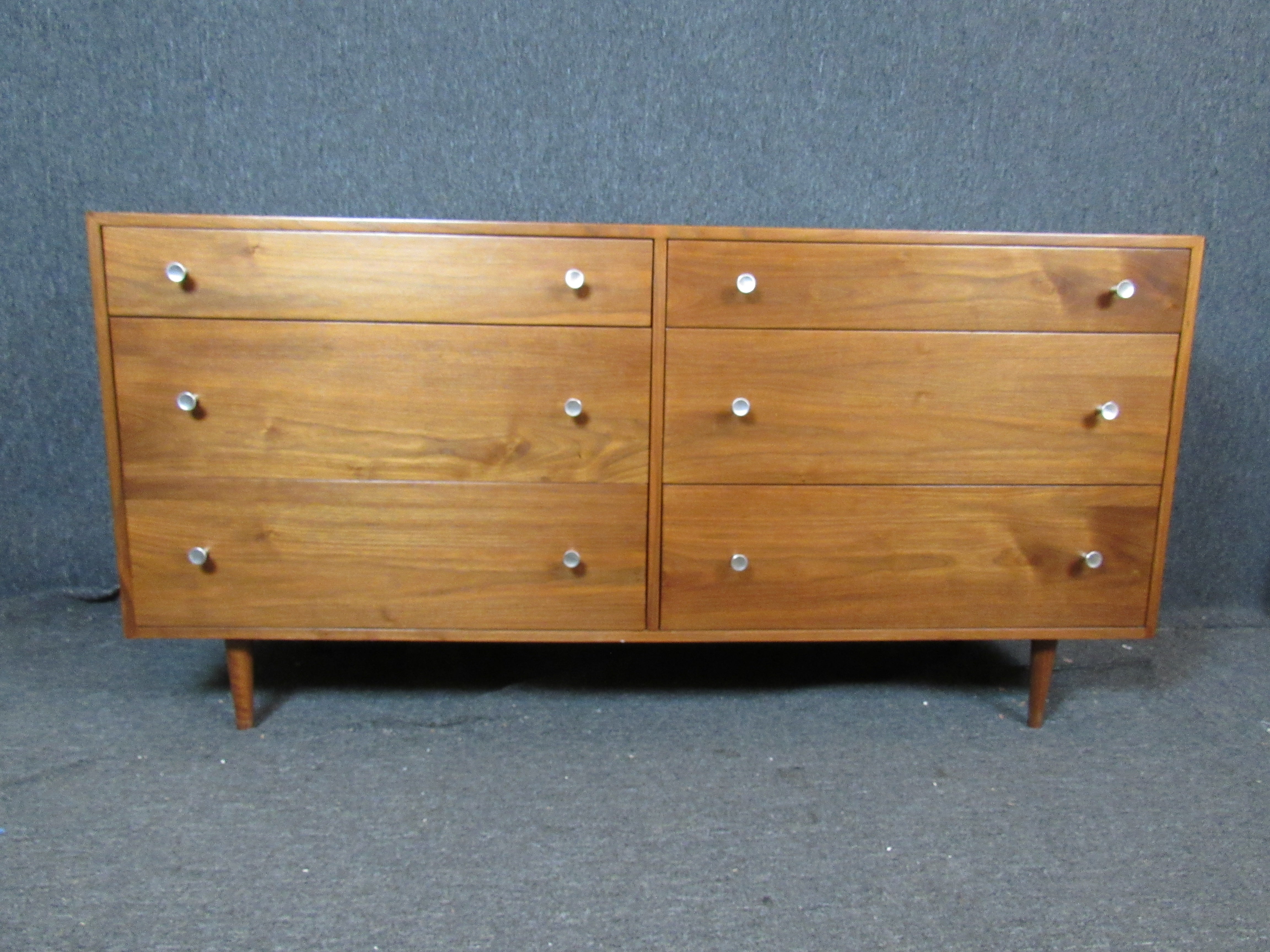 Elegance and function seamlessly blend together in this beautiful mid-century modern six-drawer dresser. Walnut construction shows off a rich, natural wood grain while complimentary satin aluminum hardware completes the look. Sure to fit in a