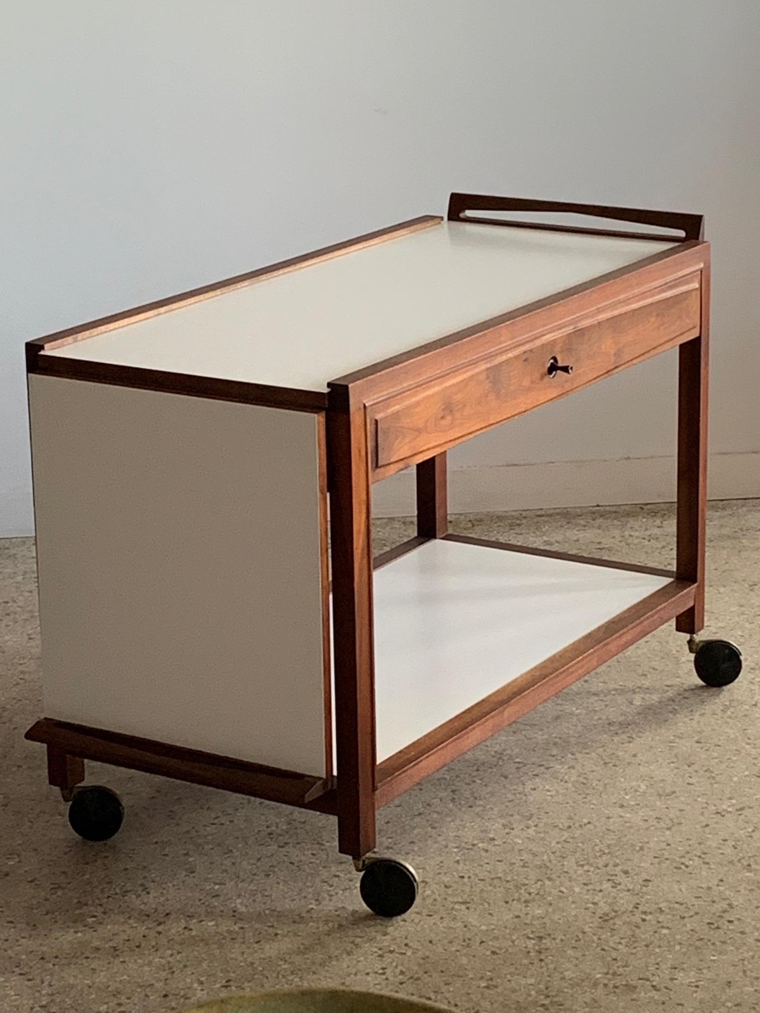 A great Mid-Century Modern Glenn of California Drop Leaf / Expandable Hostess Bar Cart designed by John Kapel extended - 63 long x 20 1/2 deep. Lower shelf, pullout / pull-out drawer, walnut and white formica.

              