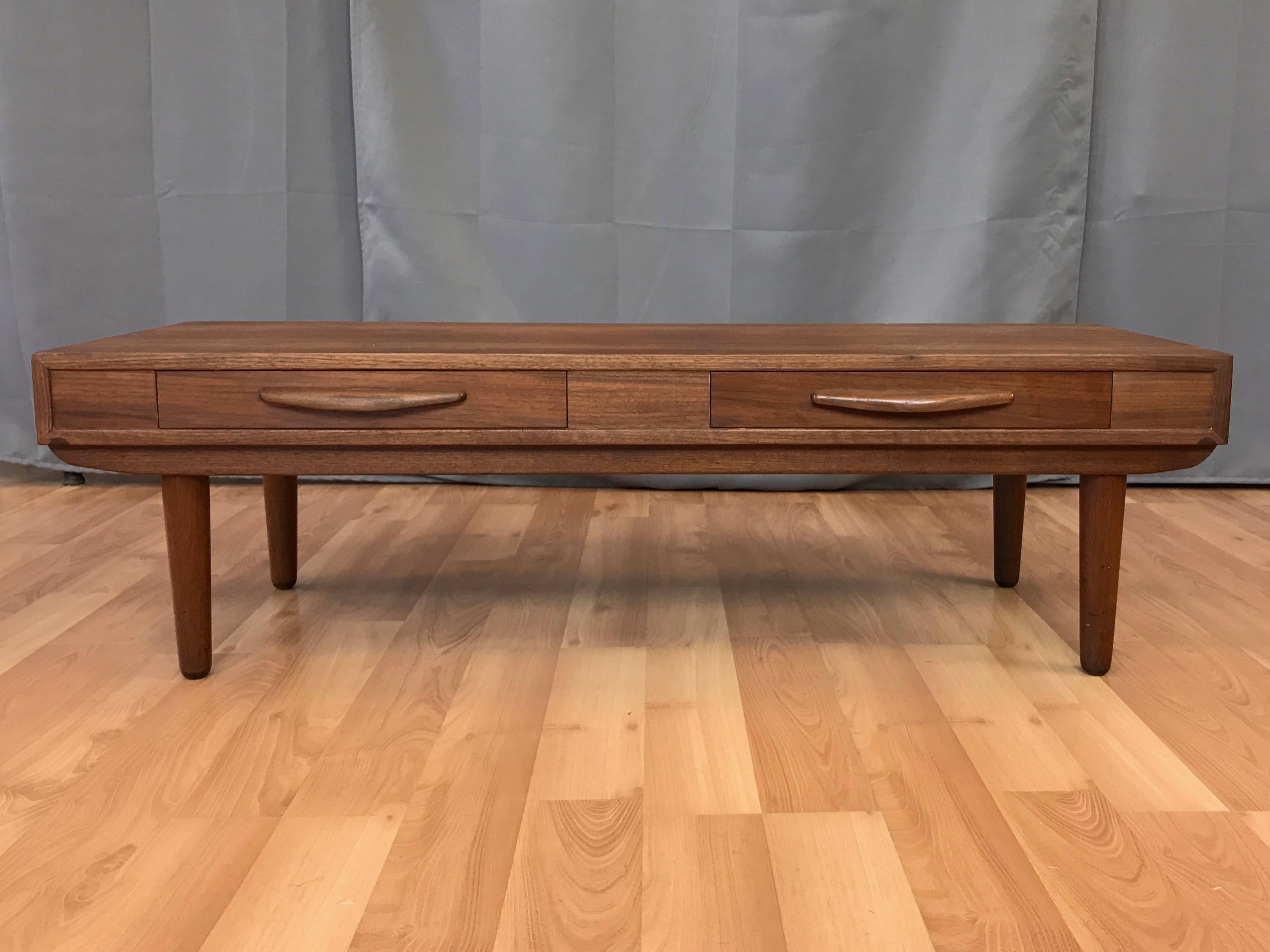 A vintage Mid-Century Modern low walnut coffee table with drawers.

Clean lines, timeless design, and handsomely figured bookmatched walnut remind of us of certain pieces by Robert Baron and Richard Thompson for Glenn of California. Features a