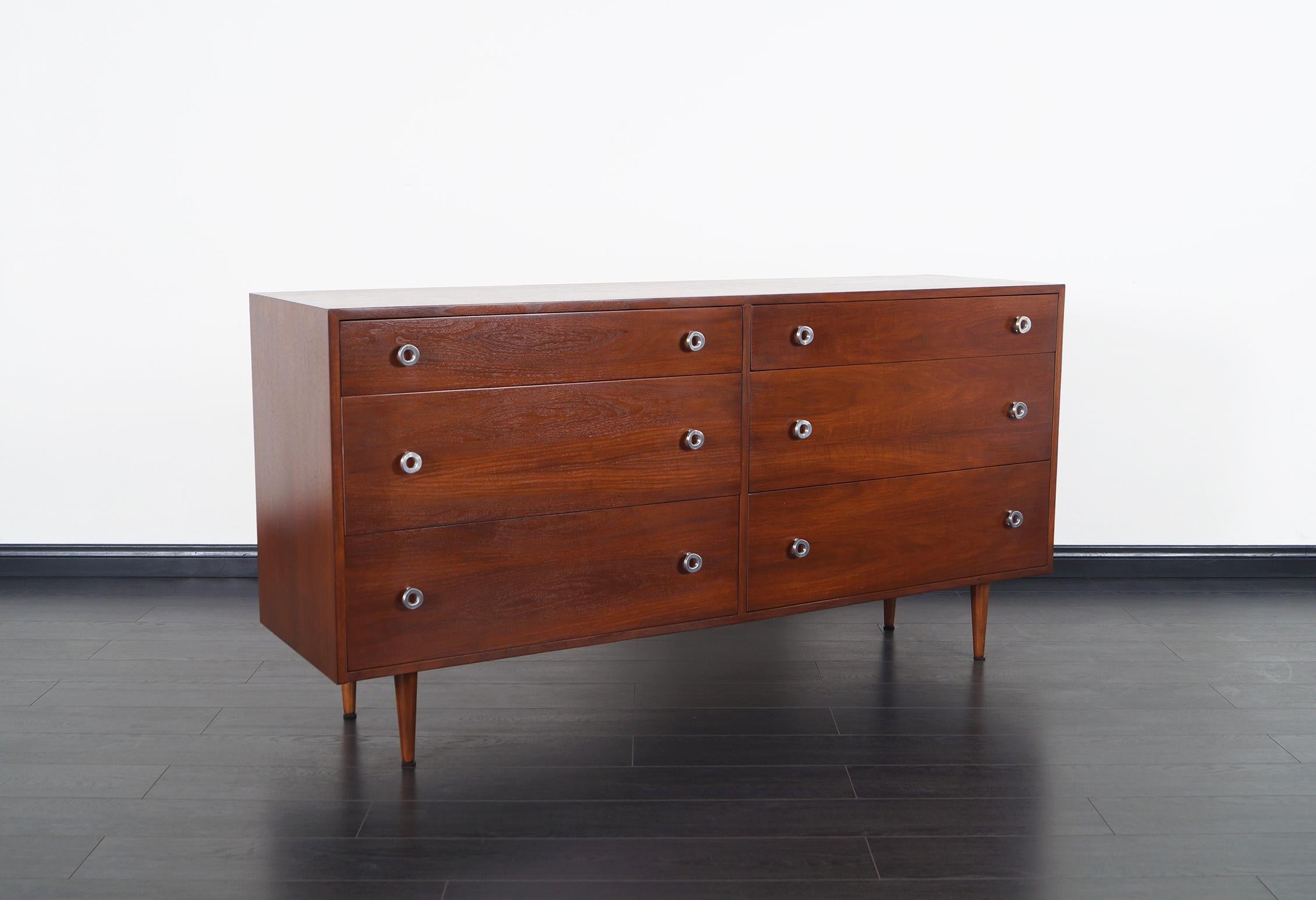 Vintage walnut dresser designed by Swedish architect Greta M. Grossman for Glenn of California. This iconic modern design is comprised of a walnut case that sits on four tapered legs featuring six dovetailed drawers. Each drawer features Grossman's