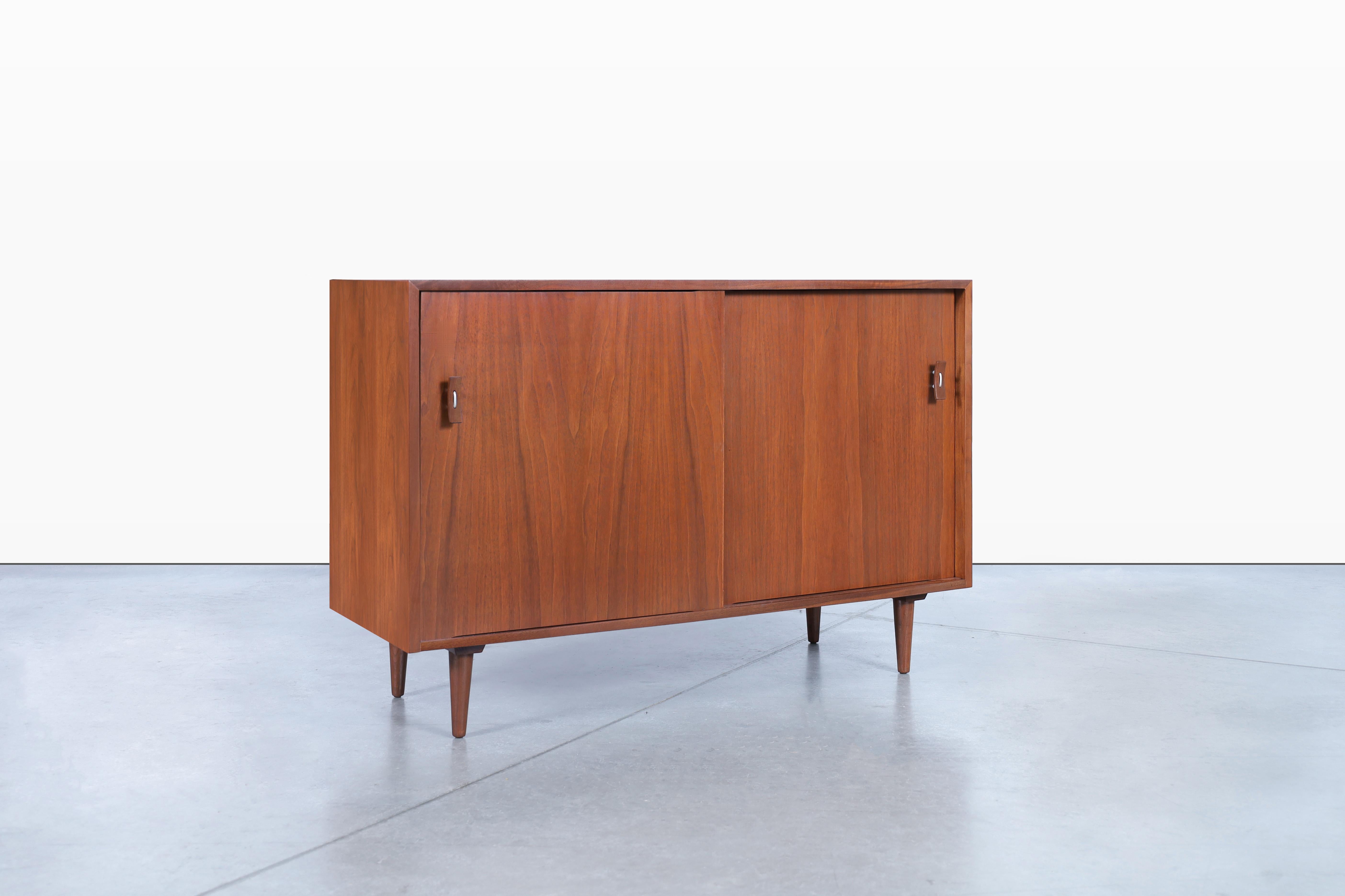 Beautiful vintage sideboard designed by Stanley Young for Glenn of California in the United States, circa 1950s. This stunning sideboard crafted from walnut showcase a beautiful grain detail that runs throughout its casing and sits on solid walnut