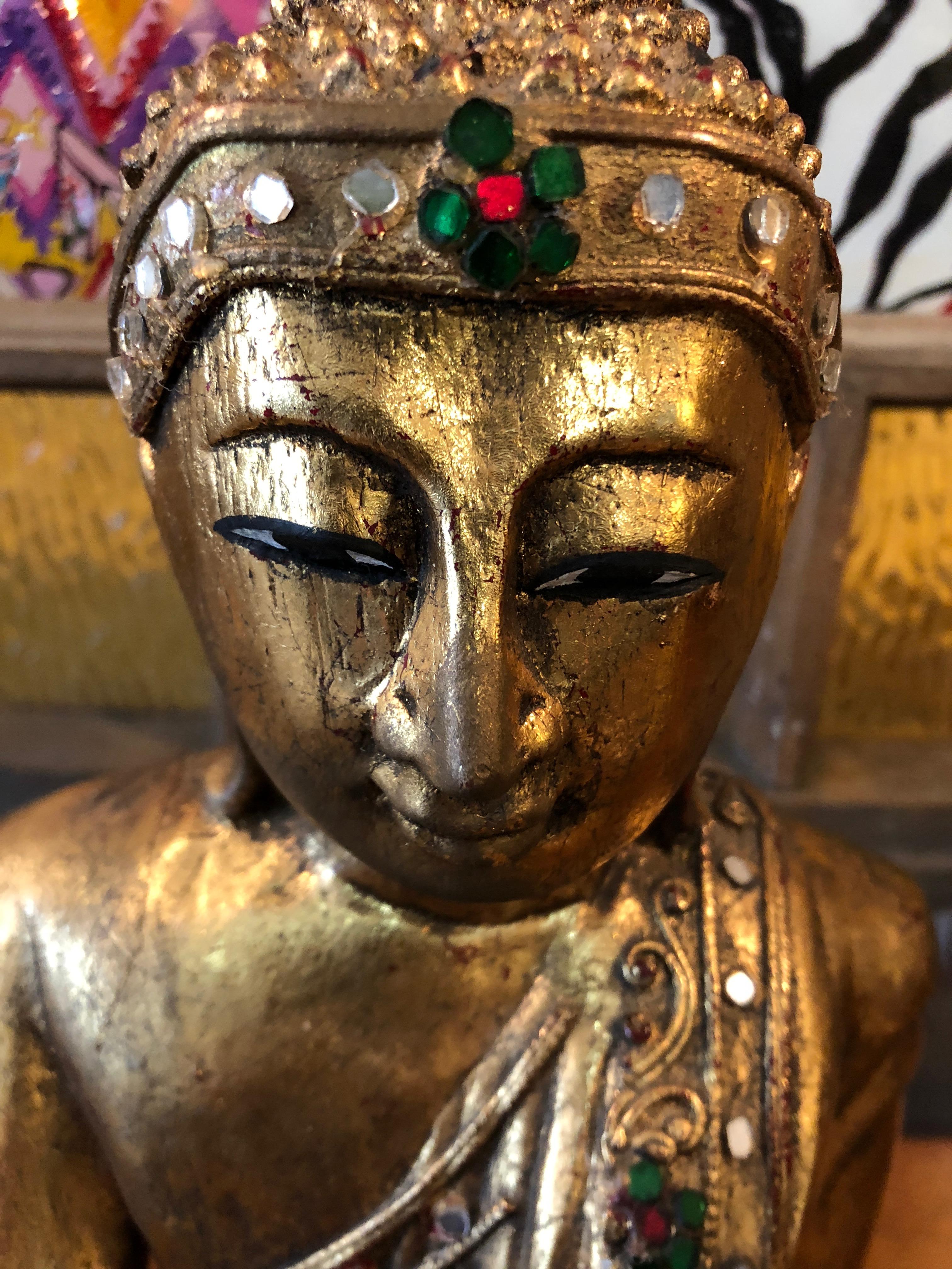 Eye-catching beautiful seated Buddha sculpture in shiny giltwood adorned with semi precious gems.