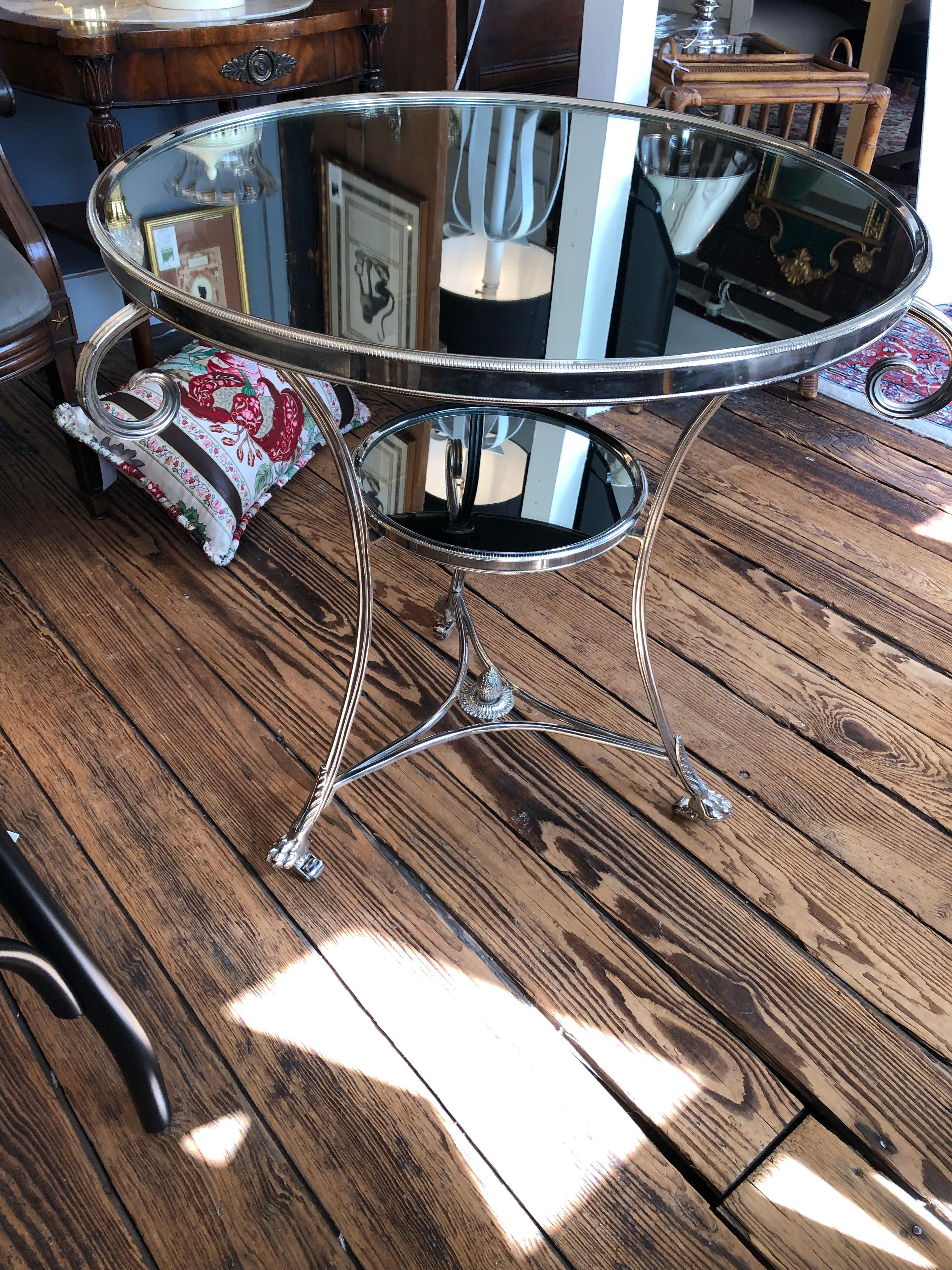 Glamorous and classy round nickel and mirrored side table in the manner of Maison Jansen having 3 curlicues beneath the mirrored surface, acorn central finial at the base, lower tier 17.25