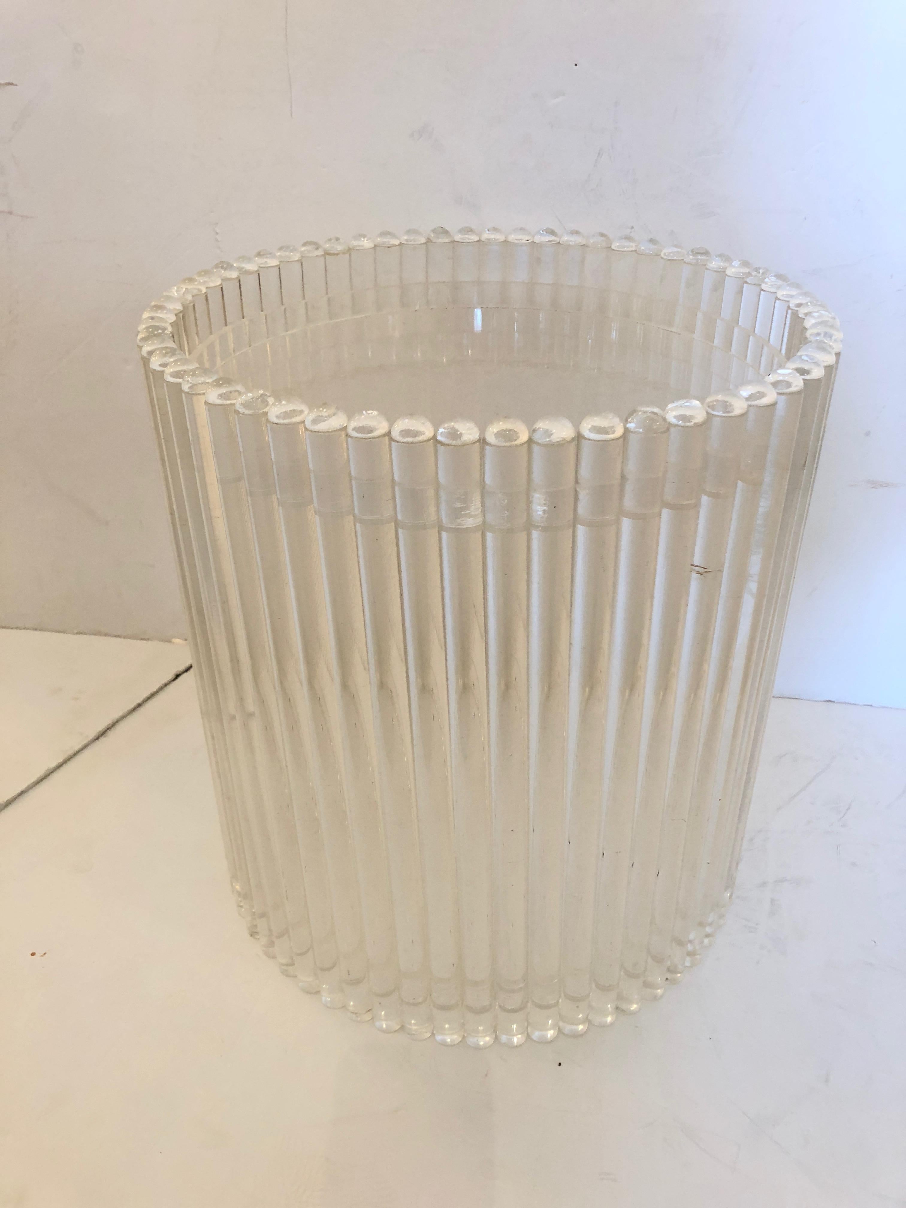 A glamorous Mid-Century Modern drum shaped Lucite end table having solid Lucite rods around the periphery.