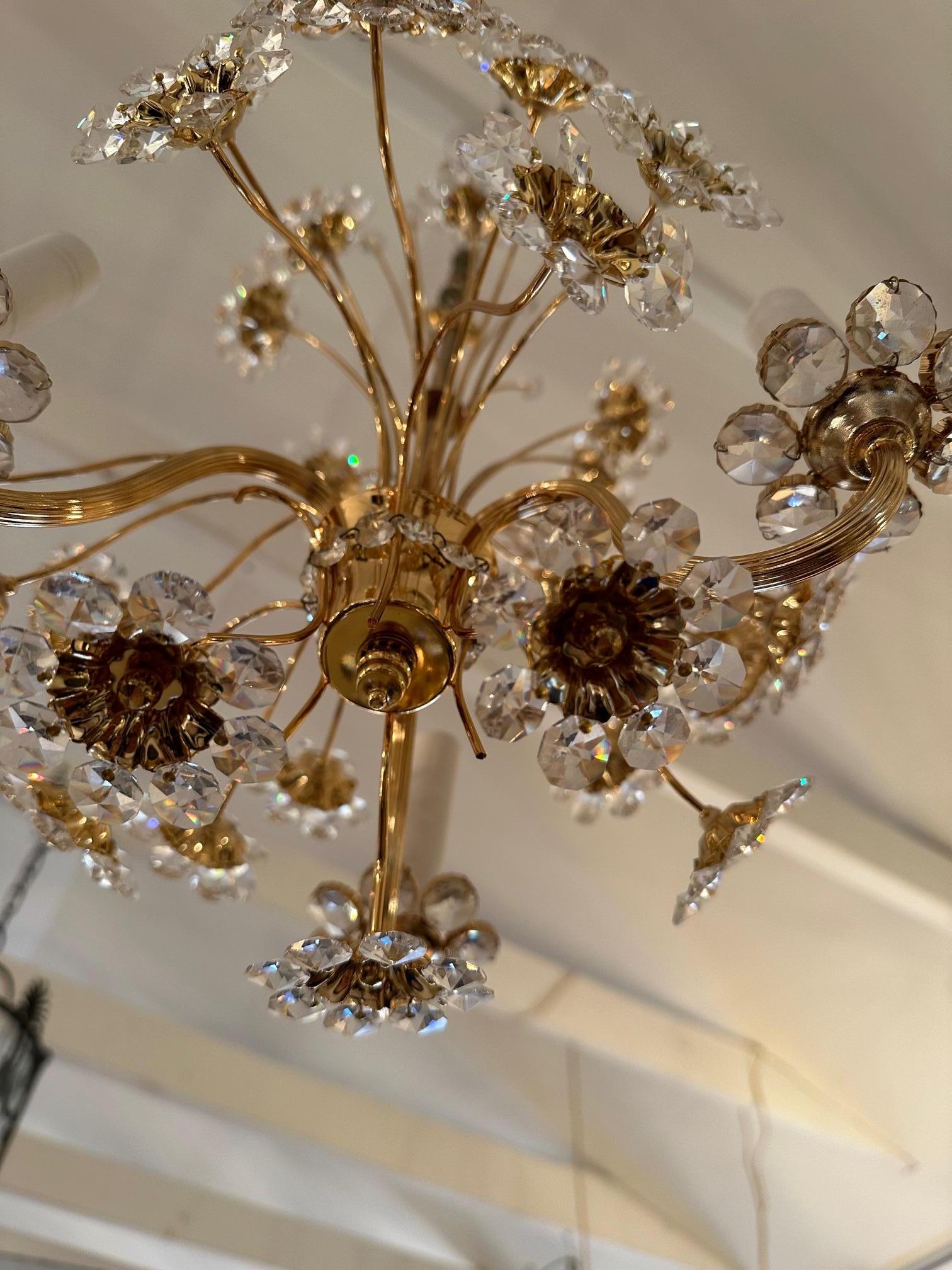 Elegant glistening flower motif German vintage chandelier having delicate 24 carat plated stems and floral centers with crystal petals. 3 arms.
Measures: 24