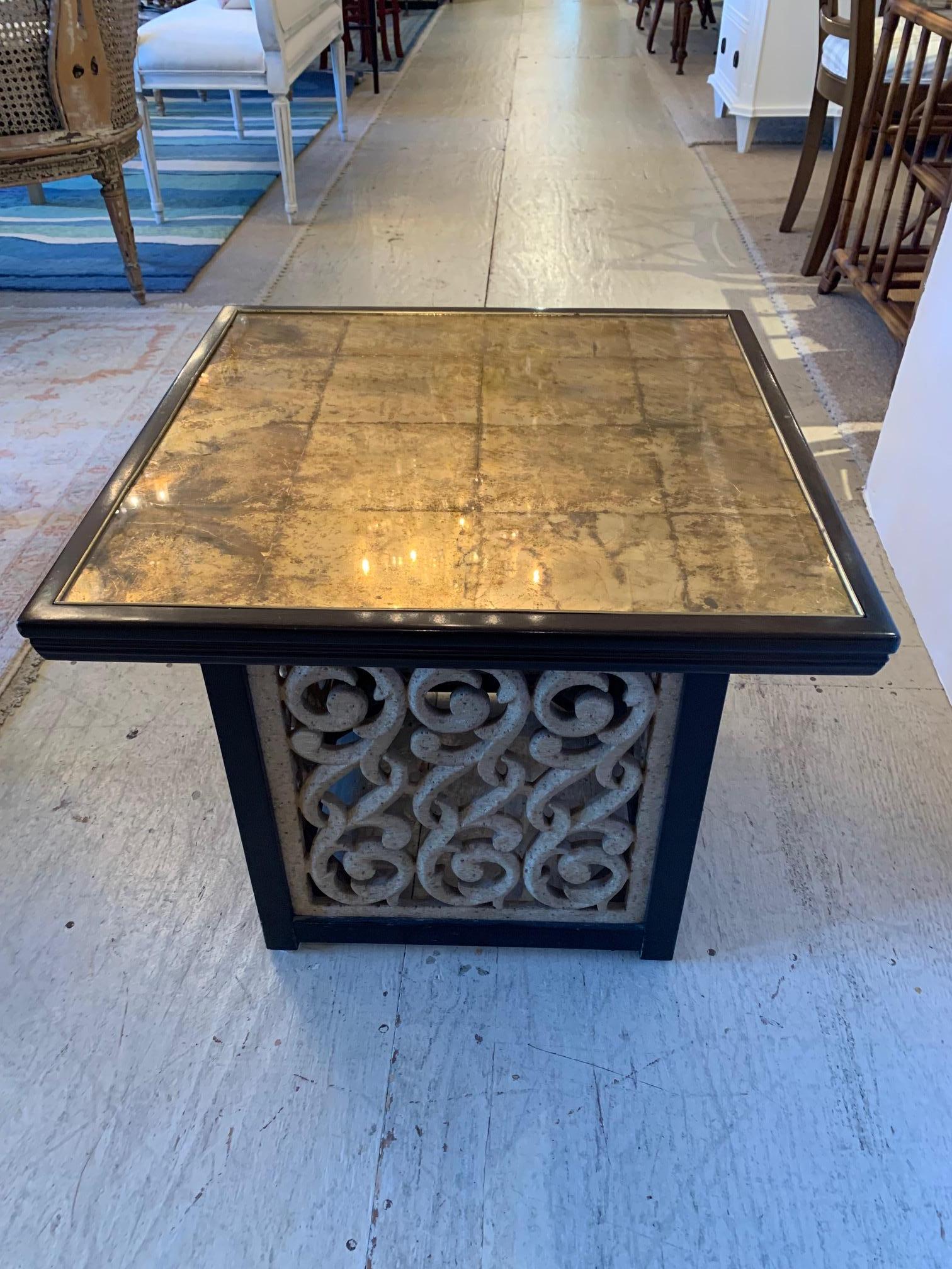 A glamorous and warmly reflective square end table having a marvelous blend of shiny gold aged mirror top framed in dark mahogany, with a contrasting earthy natural cement like open grillwork cube shaped base, also framed in handsome dark wood.