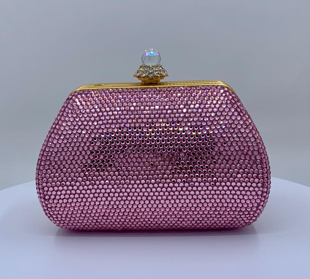 Glistening handmade couture designer, Judith Leiber, crystal minaudiere evening bag or evening clutch is completely covered in pink crystals. Gold toned metal frame with metallic gold leather lined interior and a long gold shoulder chain is tucked