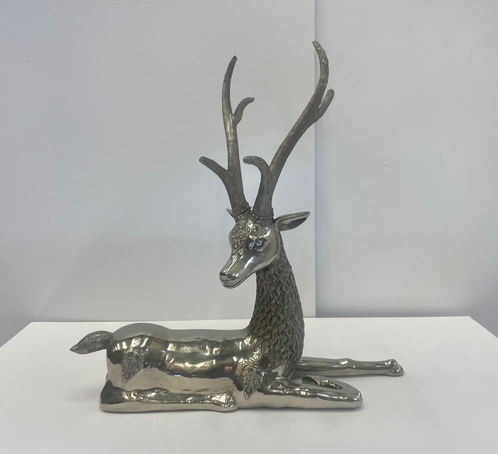 Large impressive cast brass nickel plated table top sculpture of a reclining deer with antlers.