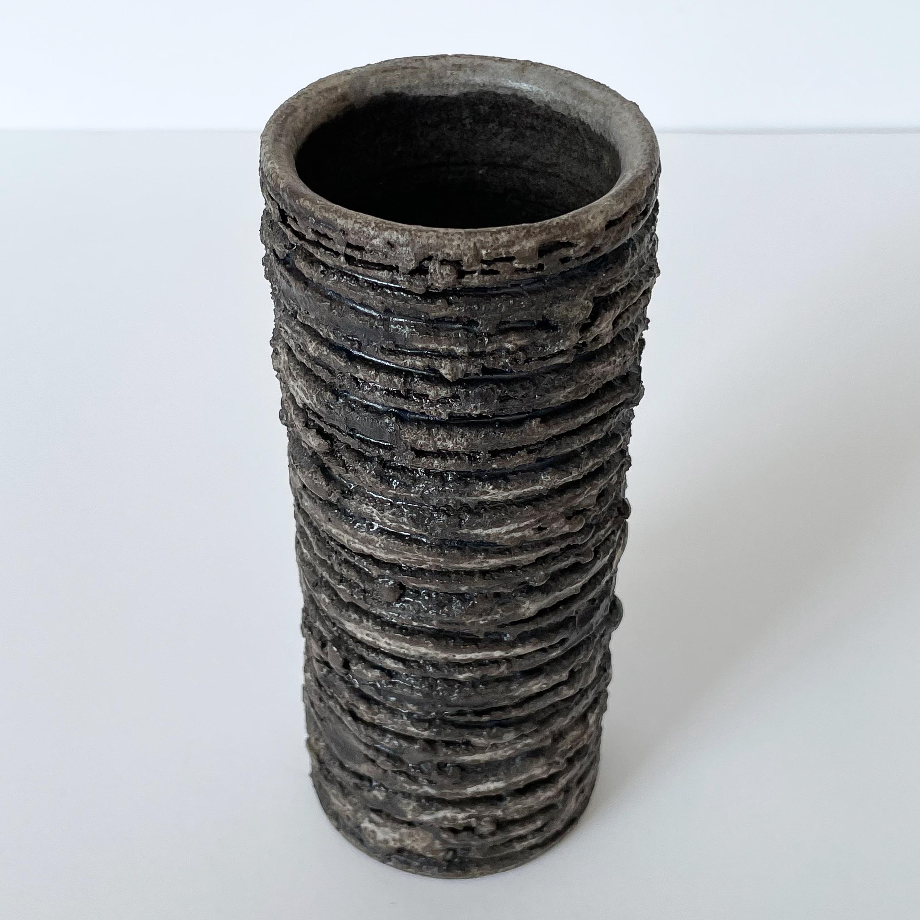 Glit pottery cylinder vase with Brutalist lava texture, circa 1960s, Iceland. Glazed in muted tones of brown, gray and black. Horizontal striations create even more texture to the chunky lava glaze. Impressed 