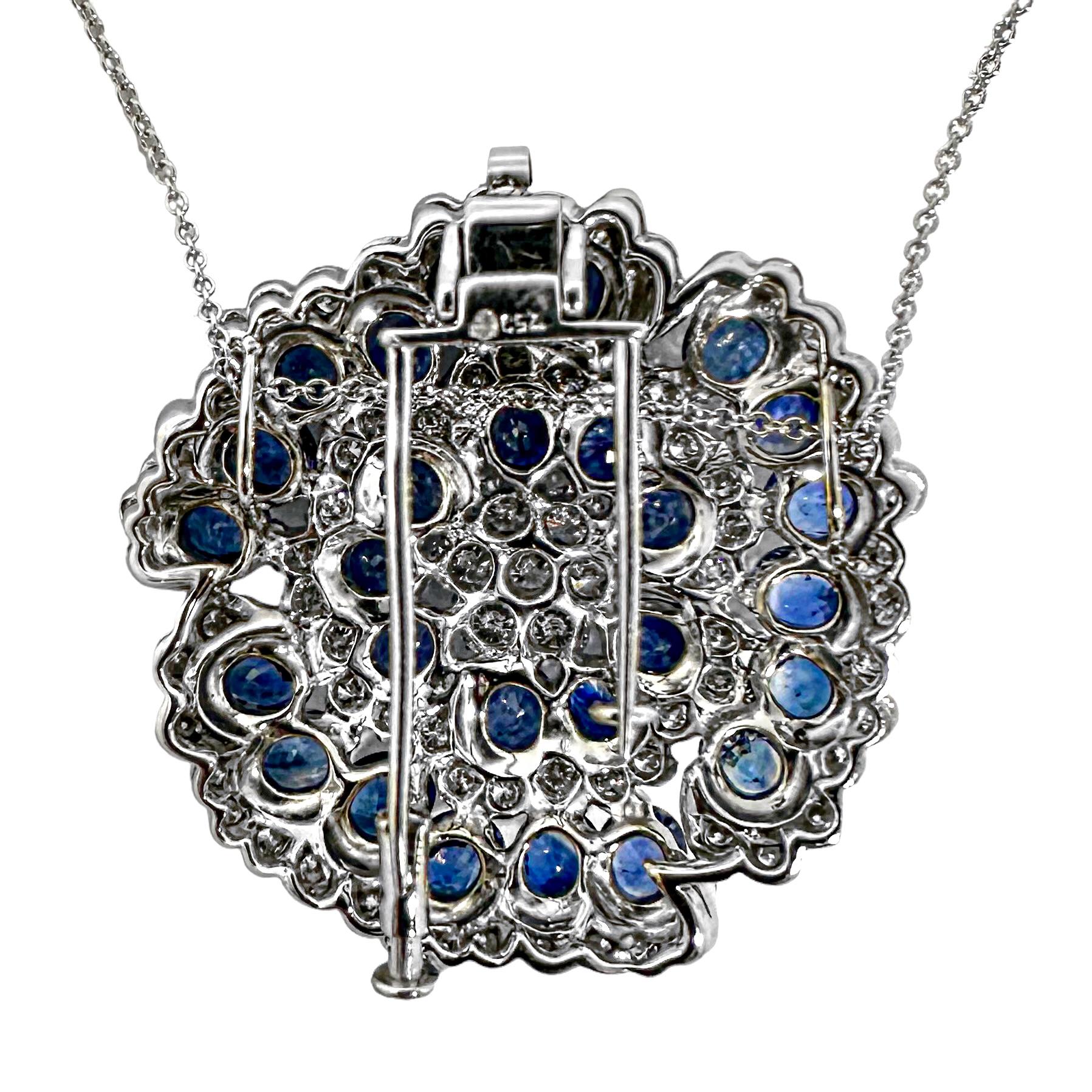 This sublime vintage 18k white gold vintage camellia flower pendant / brooch is set over it's entire surface with alternating lines of brilliant round diamonds and vivid blue oval faceted natural sapphires. The effect is quite commanding and