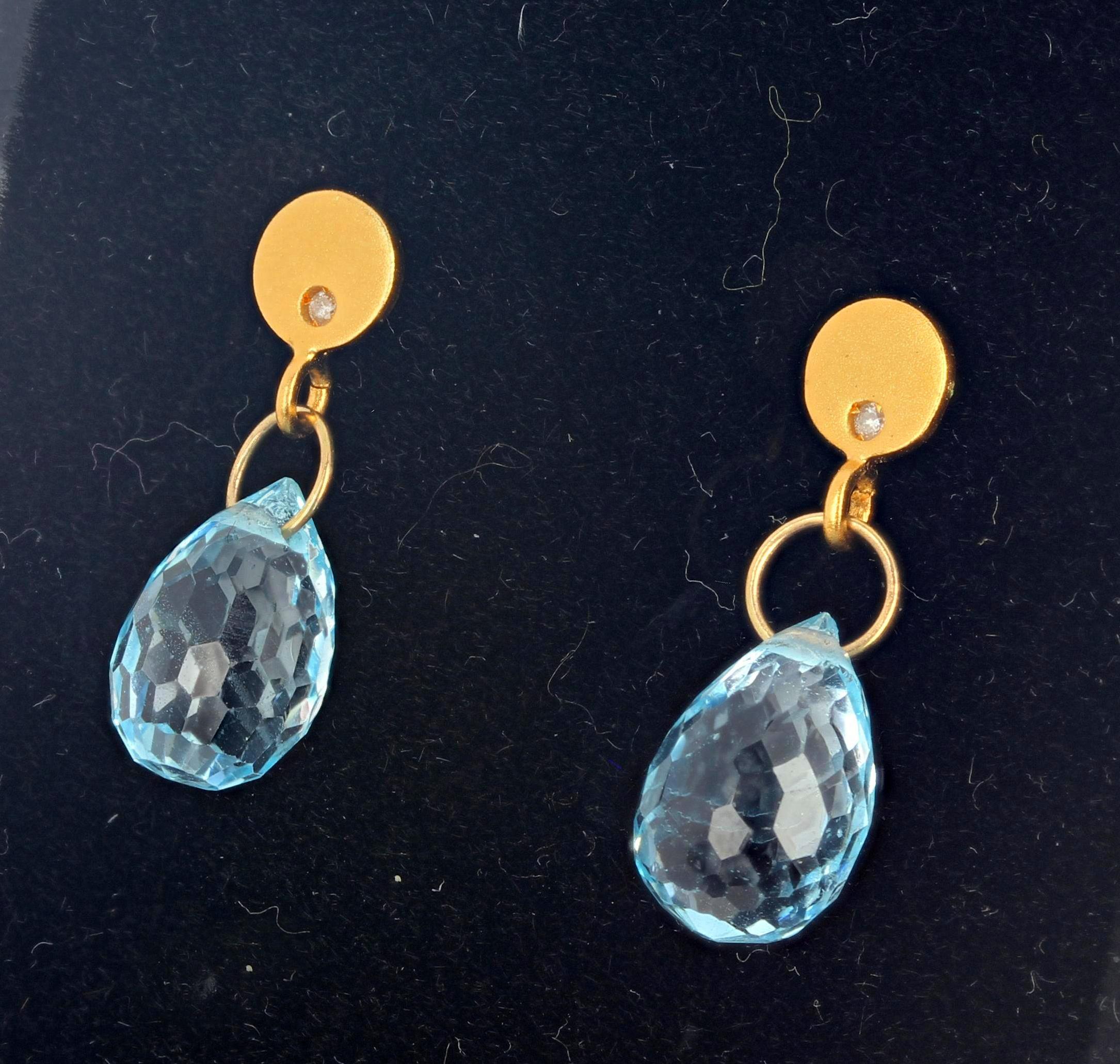These wonderful sparkling glittery blue Topaz swing from 14Kt yellow gold stud earrings. There is a natural real Diamond in each of the earrings to match the glitter of the Topaz.  They hang approximately 7/8