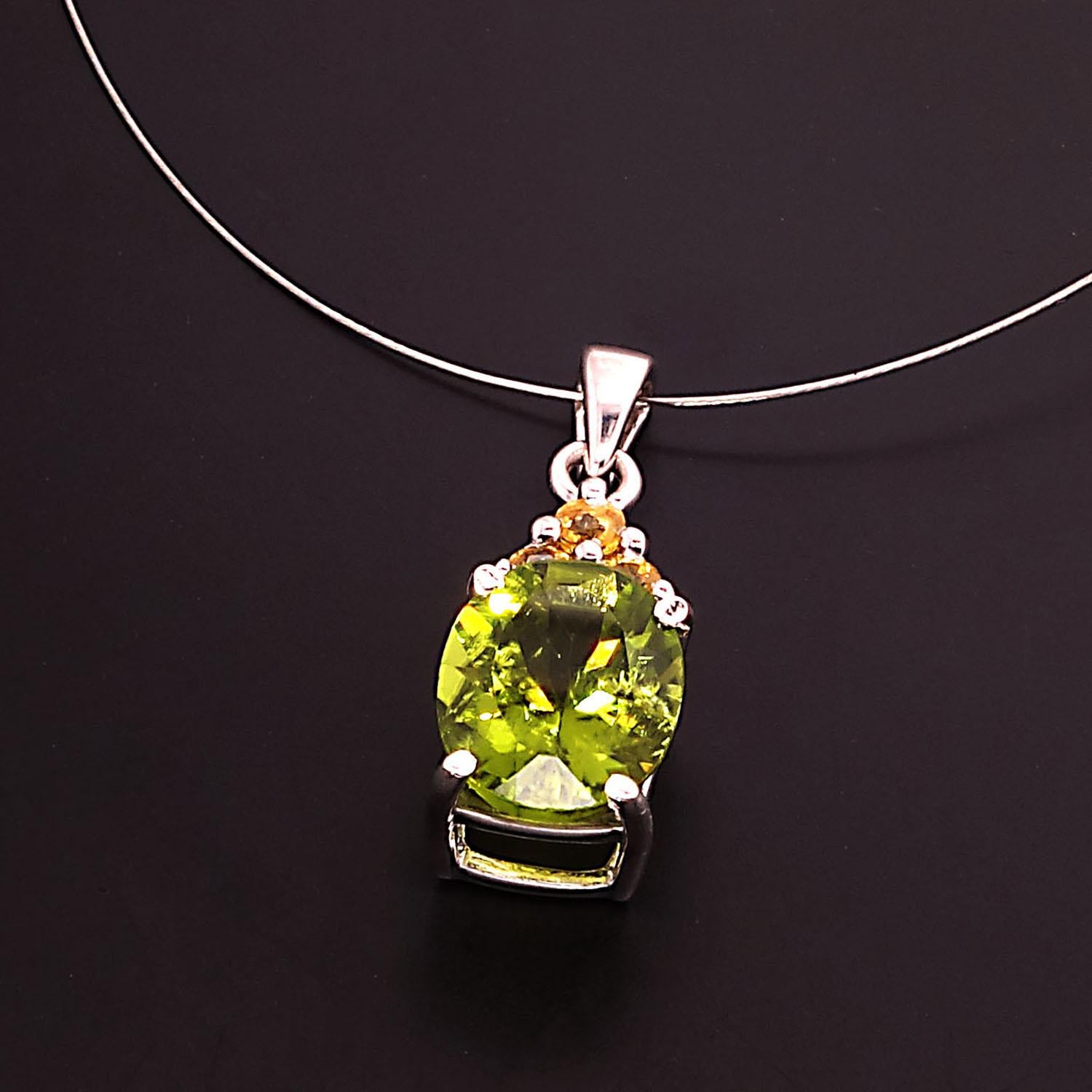 Unique, sparkling oval green Peridot pendant with accents of Yellow Sapphires.  This gorgeous pendant will sparkle and wink as you move.  The 3.85ct  peridot is accented with three Yellow Sapphires with a total weight of 0.37ct. The Peridot and