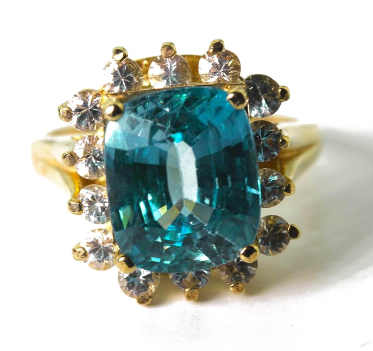 Amazing brilliant glittereing 7 carat blue Zircon adorned with a surround of brilliant white Sapphires set in a unique handmade 14Kt yellow gold ring size 7 (sizable)  