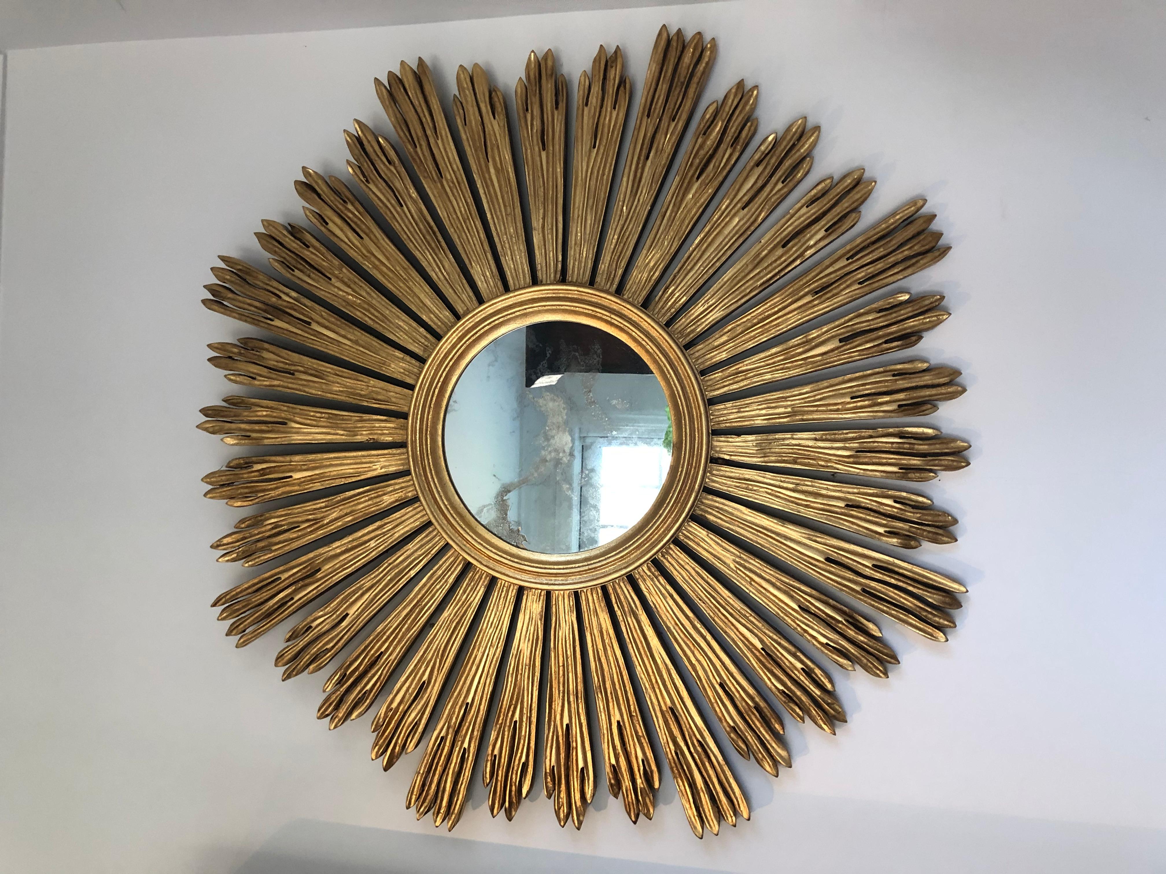 Vintage sunburst mirror in gilded wood and antiqued glass. The piece has wonderful patina and is marked Italy on reverse.