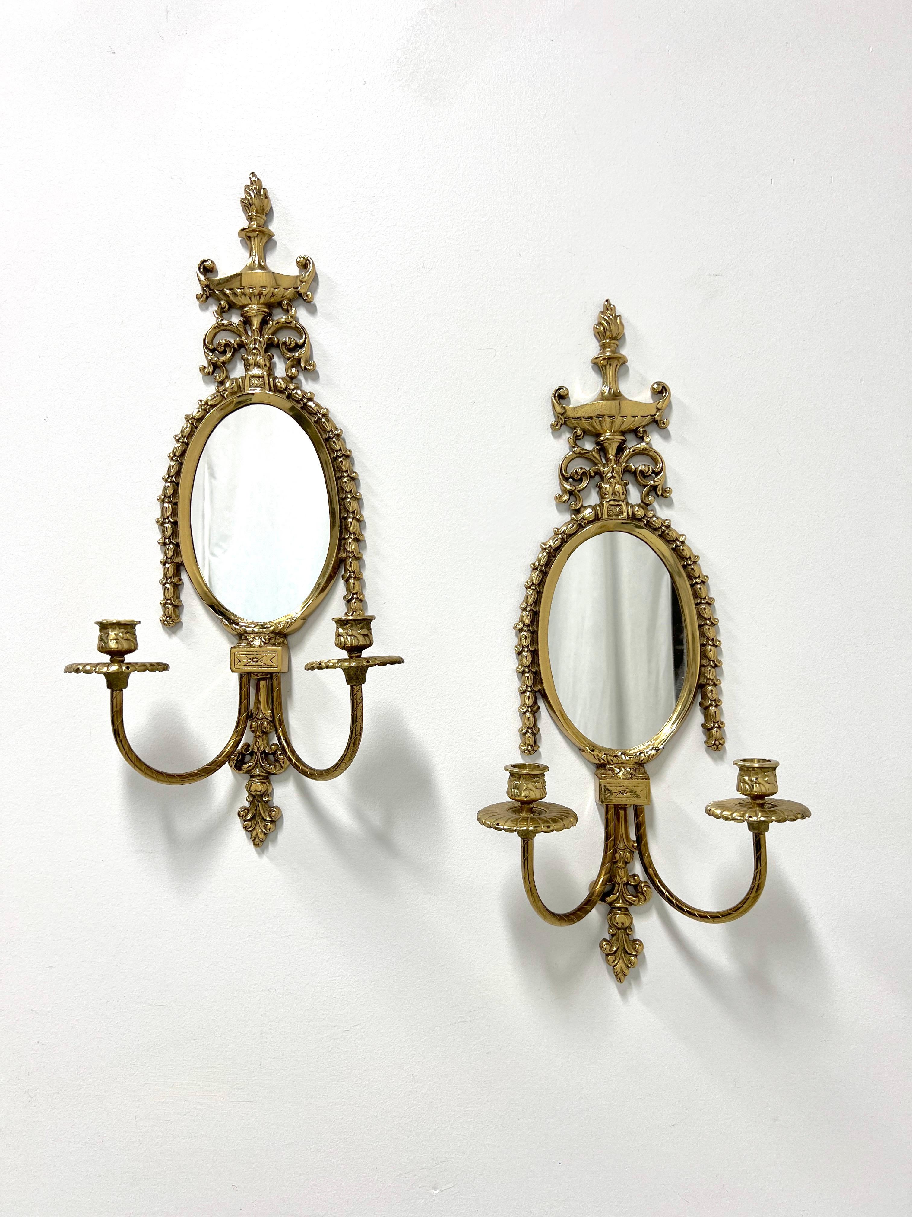 A pair of French Provincial style mirrored candle wall sconces by Glo-Mar Artworks. Solid brass decoratively sculpted with a center oval shaped mirror, garland swag draping the mirror top, urn shape to very top, decorative base, and two curved arms