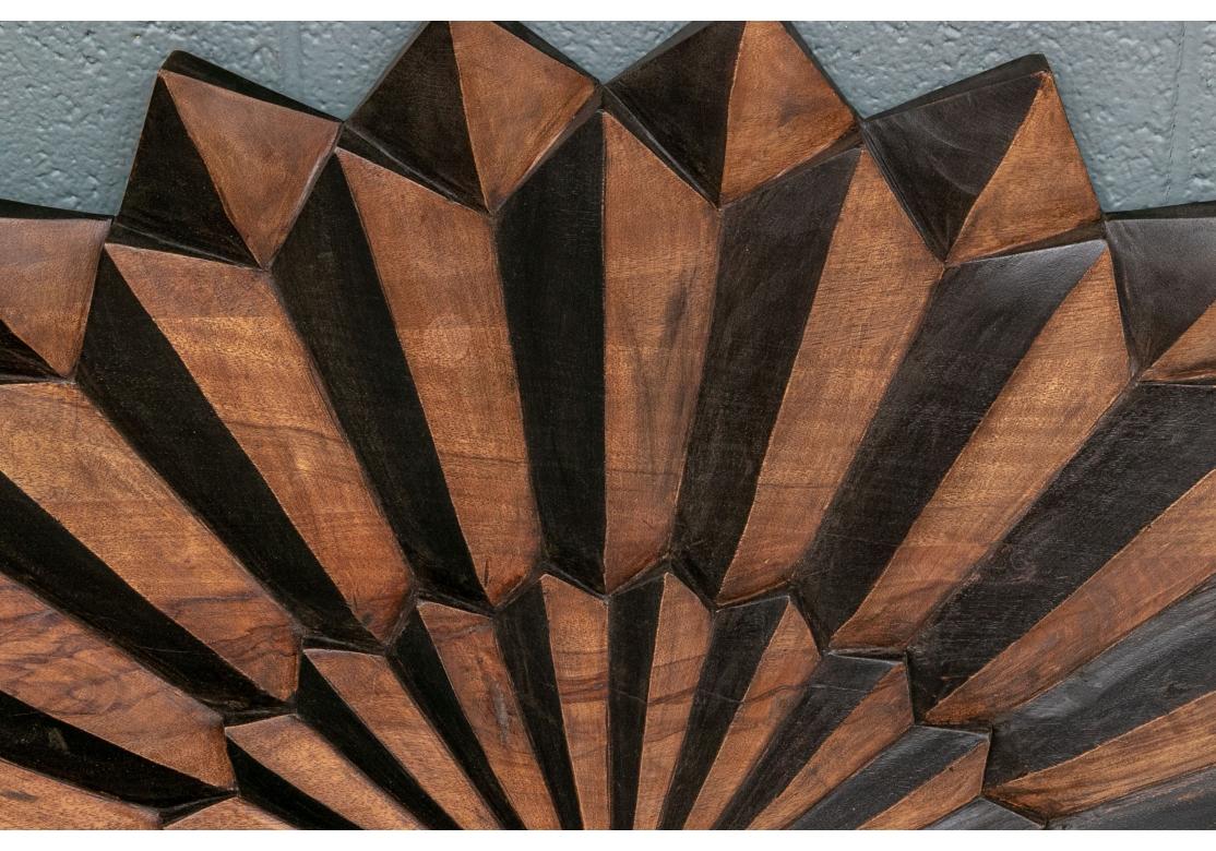 Striking Sunburst  Design in overlapping layers of contrasting colored woods. A large dimensional sunburst form in three overlapping levels with sharp edged rays with a small center convex mirror. Made in India.
Diam. 40