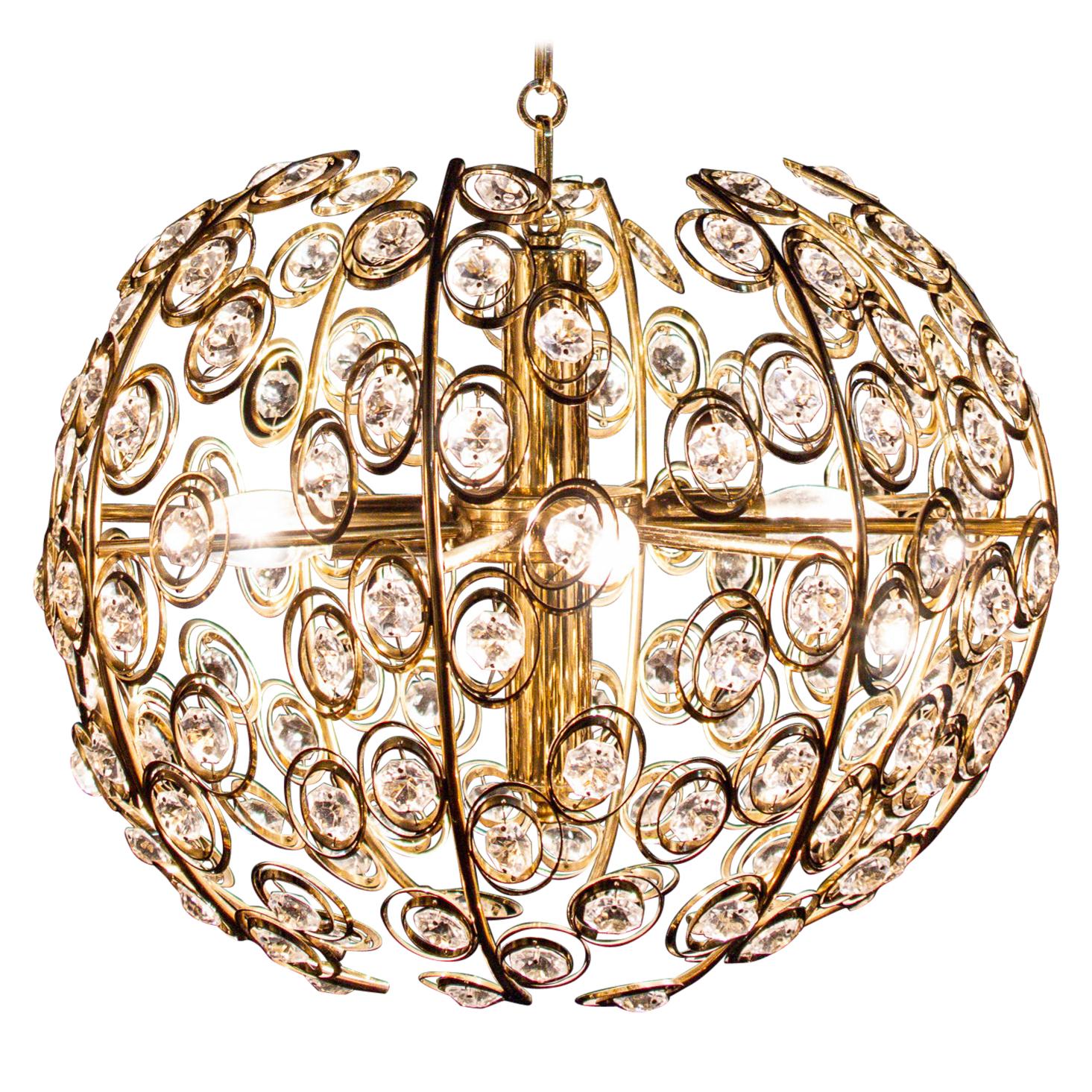 Lampadario glamour in ottone placcato oro e cristallo a forma di diamante disegnato nel 1960 da Gaetano Sciolari.
Quattro lampadine E14.
