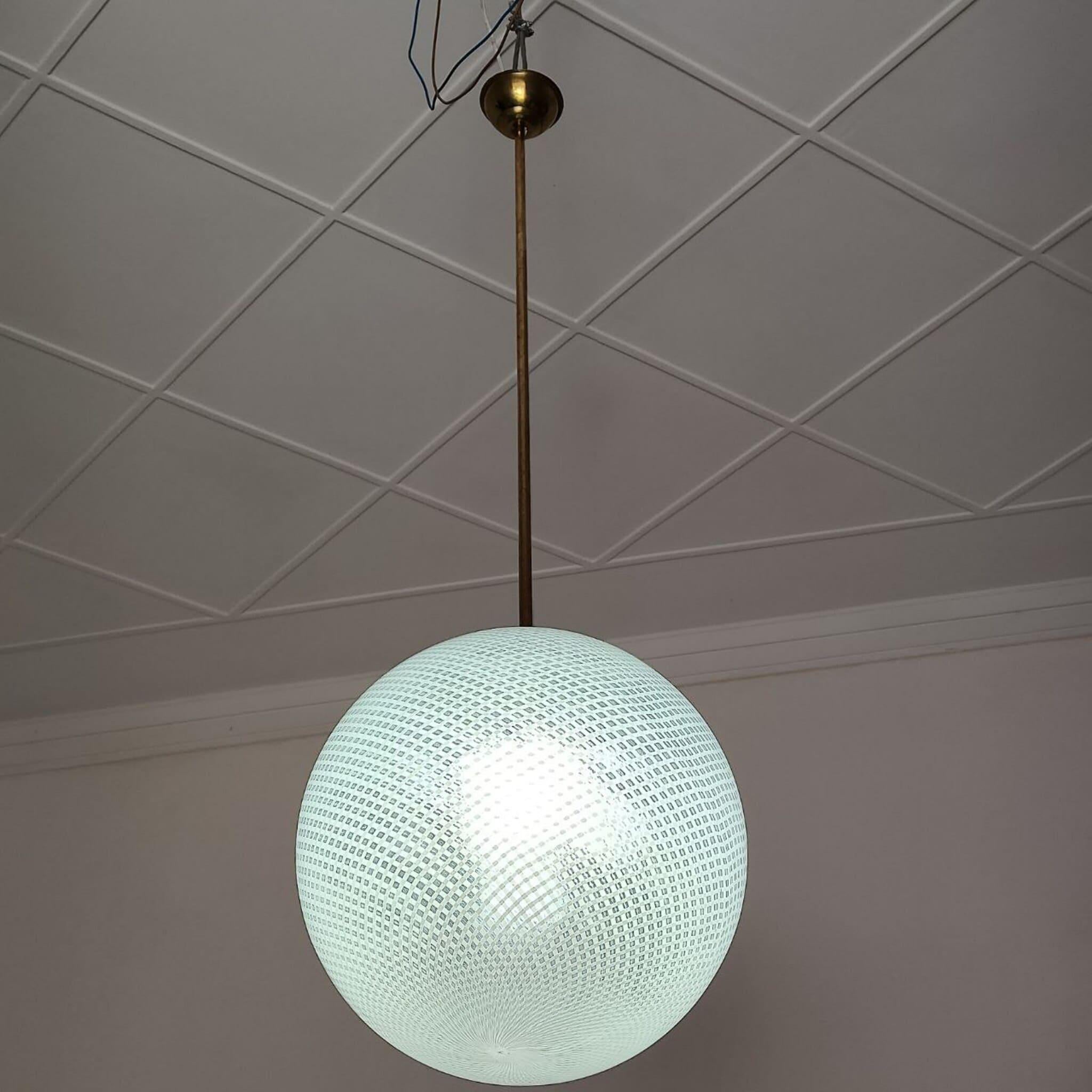 This elegant pendant lamp, attributed to Carlo Scarpa for Venini, dates back to the 1940s and represents a perfect synthesis between Murano glass art and architectural design.

The spherical diffuser, hand-blown according to the ancient reticello