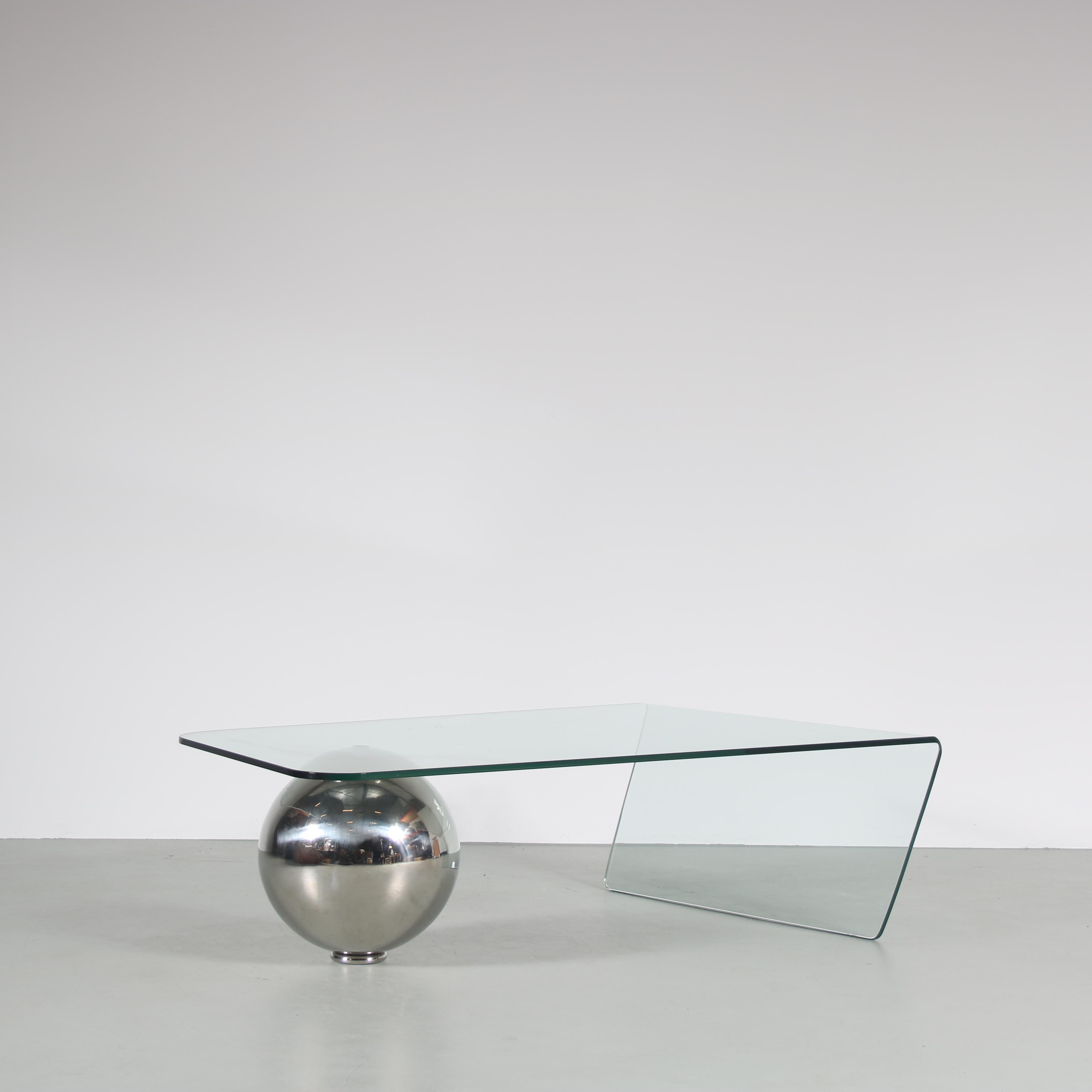 An eye-catching coffee table, model “Globe”, designed by Giorgio Cattelan and manufactured by Cattelan in Italy around 1970.

Made of high quality glass, bent into shape and balanced with a chrome plated metal ball shape at the other end. This