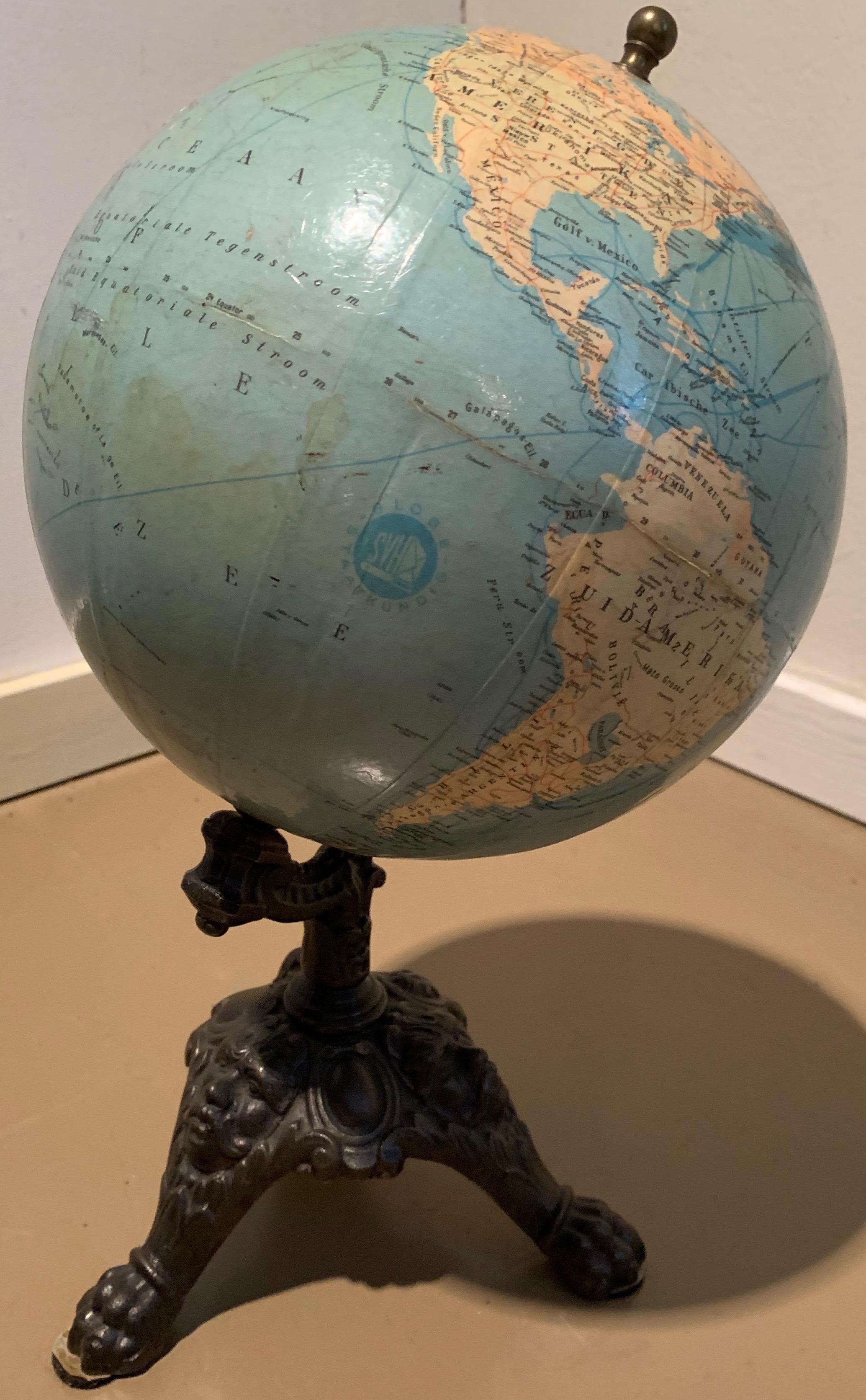 Globe standing on a cast iron foot with figures on base. 
Dutchmade, early 1900s.