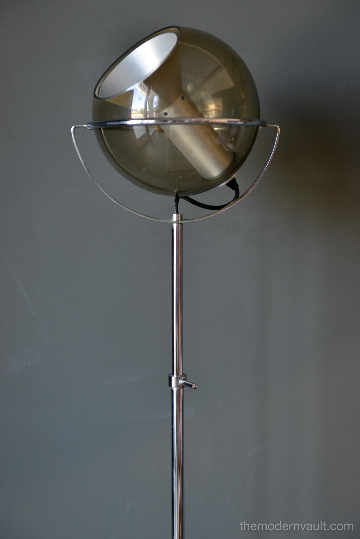 Globe floor lamp by Frank Ligtelijn for RAAK, circa 1961. Smoked glass globe on an adjustable chrome stand. Original 3 star iron base and foot switch with original wiring. Chrome is in very good condition as well as the glass globe. Floating glass