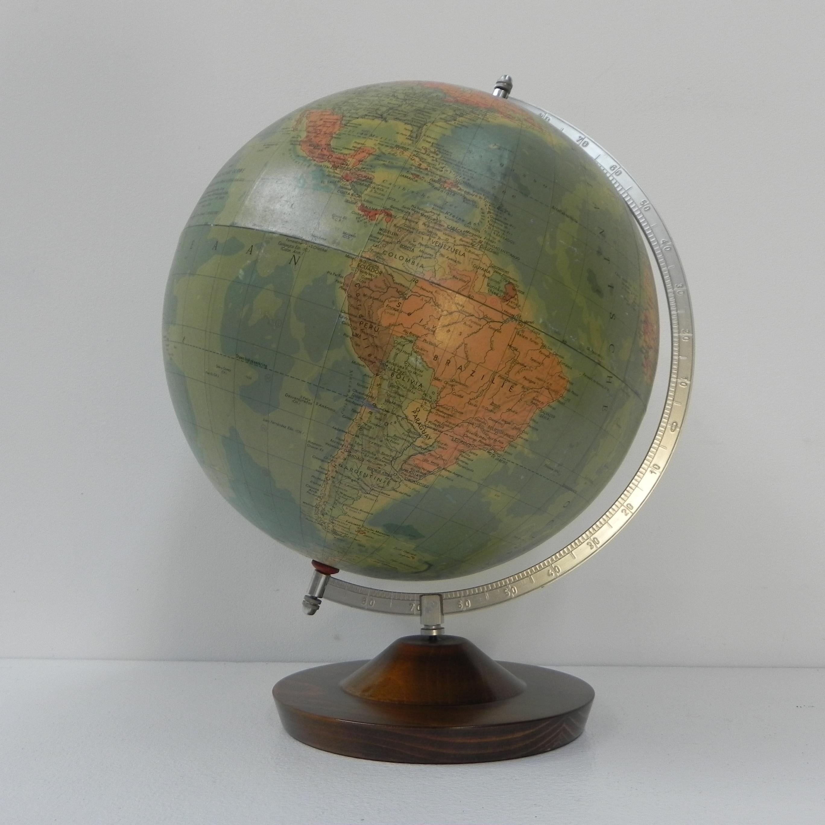 This beautiful globe has some minor damage
at the height of the Galapagos Islands.

Height: 50 cm.
Width: 35 cm.
Depth (= Ø sphere): 33 cm.
Origin: The Netherlands, 1960s.
Material: cardboard / aluminum / wood.