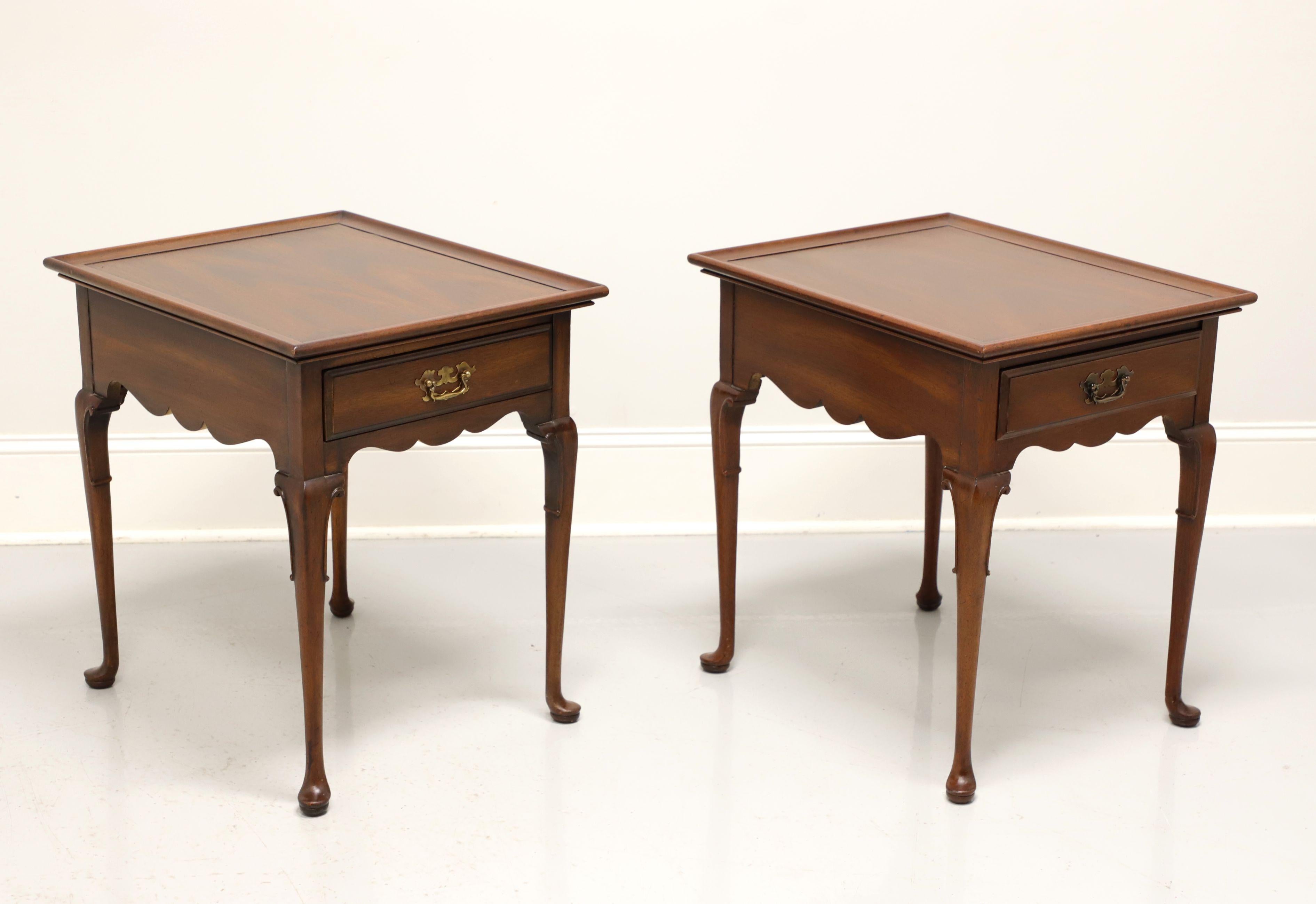 A pair of Georgian style end tables by Globe Furniture. Mahogany with brass hardware, decorative knees, cabriole legs and pad feet. Each features one drawer of dovetail construction. Made in the USA, in the mid 20th century.

Measures: 20 W 24 D