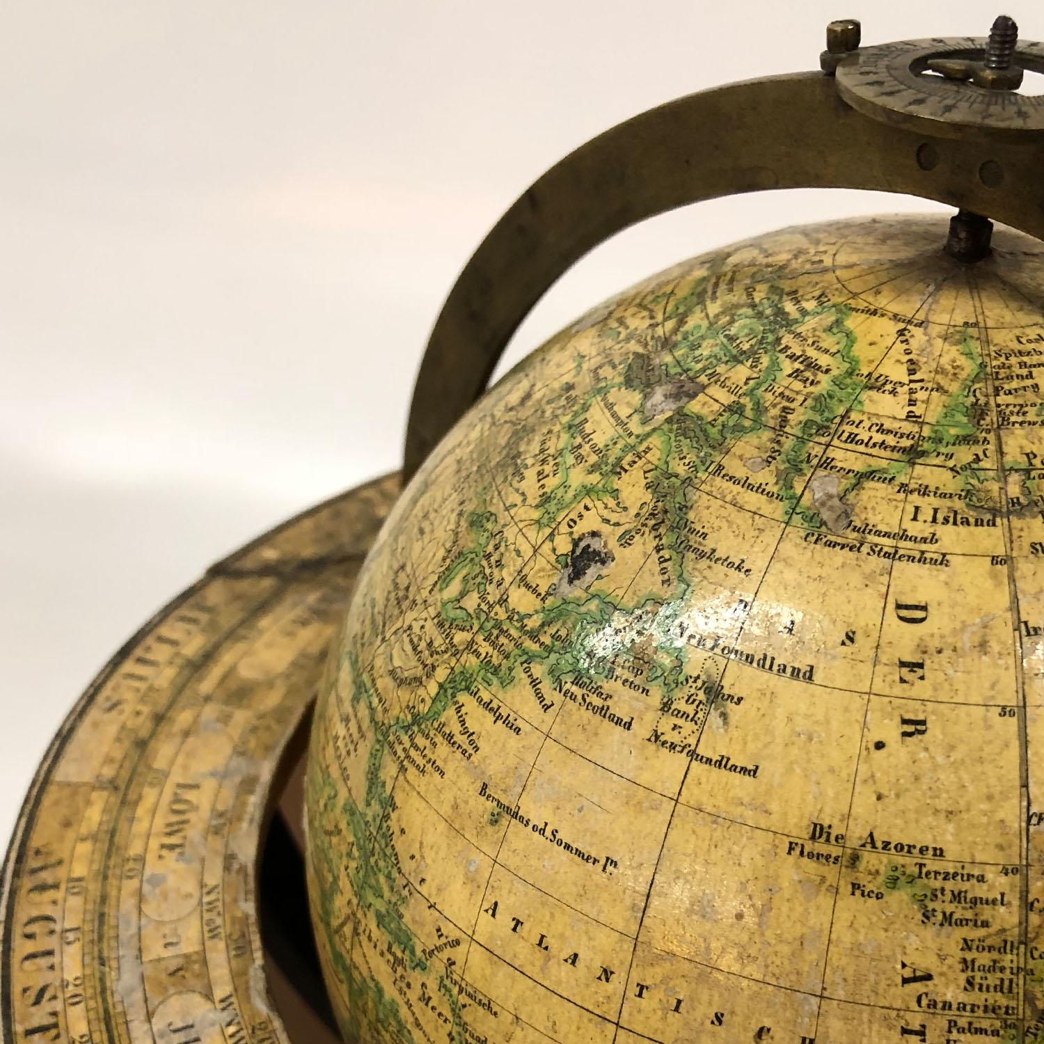 Small globe standing on a tripod base with brass meridian and a ring with zodiac signs and calendar. Located and dated on the Globe “Weimar 1843, Geograph. (isches) Institut. Verfertigt v. J. C. Gorick.”. Small imperfections on the map, especially