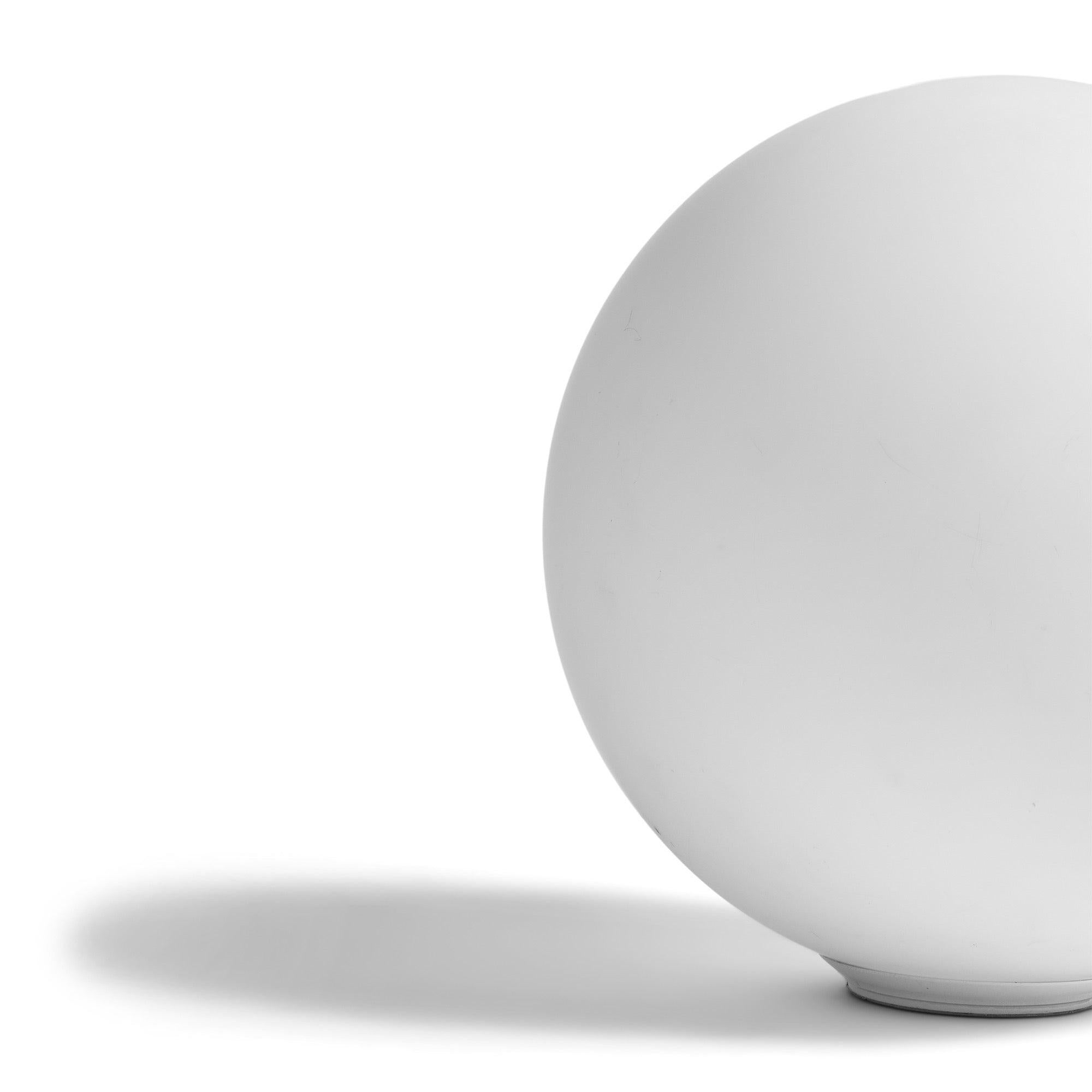 The simple and bright white lamp has a hand-blown glass globe with a subtle texture, supported by a hidden plastic base.??Artemide, a company established in 1959, has a history of creating modern lighting fixtures like table lamps, floor lamps, wall
