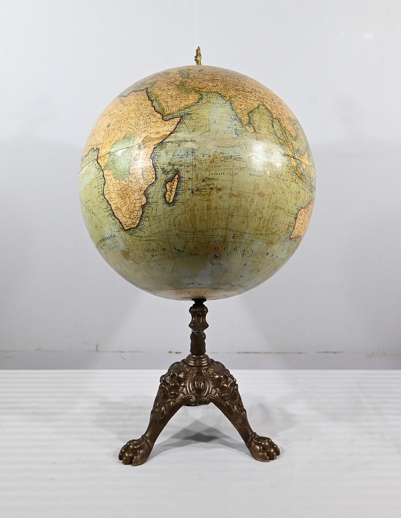 Globe terrestre du XIXe siècle par J. Lebègue & Cie. Ce globe est doté d'une monture solide et d'une base tripode en fonte décorée de mascarons et terminée par des pieds griffus. La sphère est recouverte d'un papier lithographié représentant une
