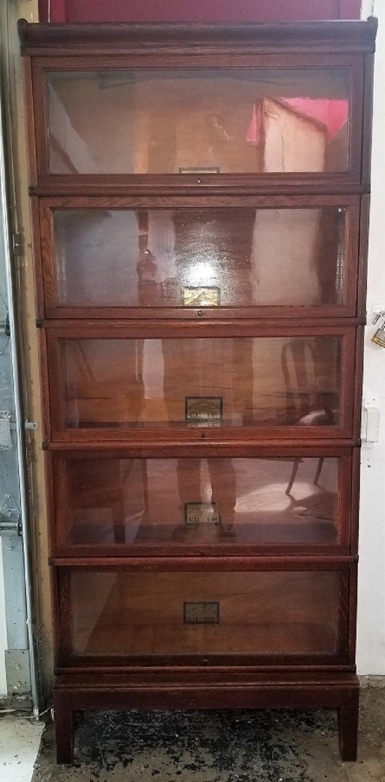 Presenting a rare early 20th century Globe Wernicke 5-section barristers bookcase.

From circa 1910 and made of dark oak with boxwood lining in each drawer.

5 detachable sections on a solid footed base and pelmet top.

Each section has a