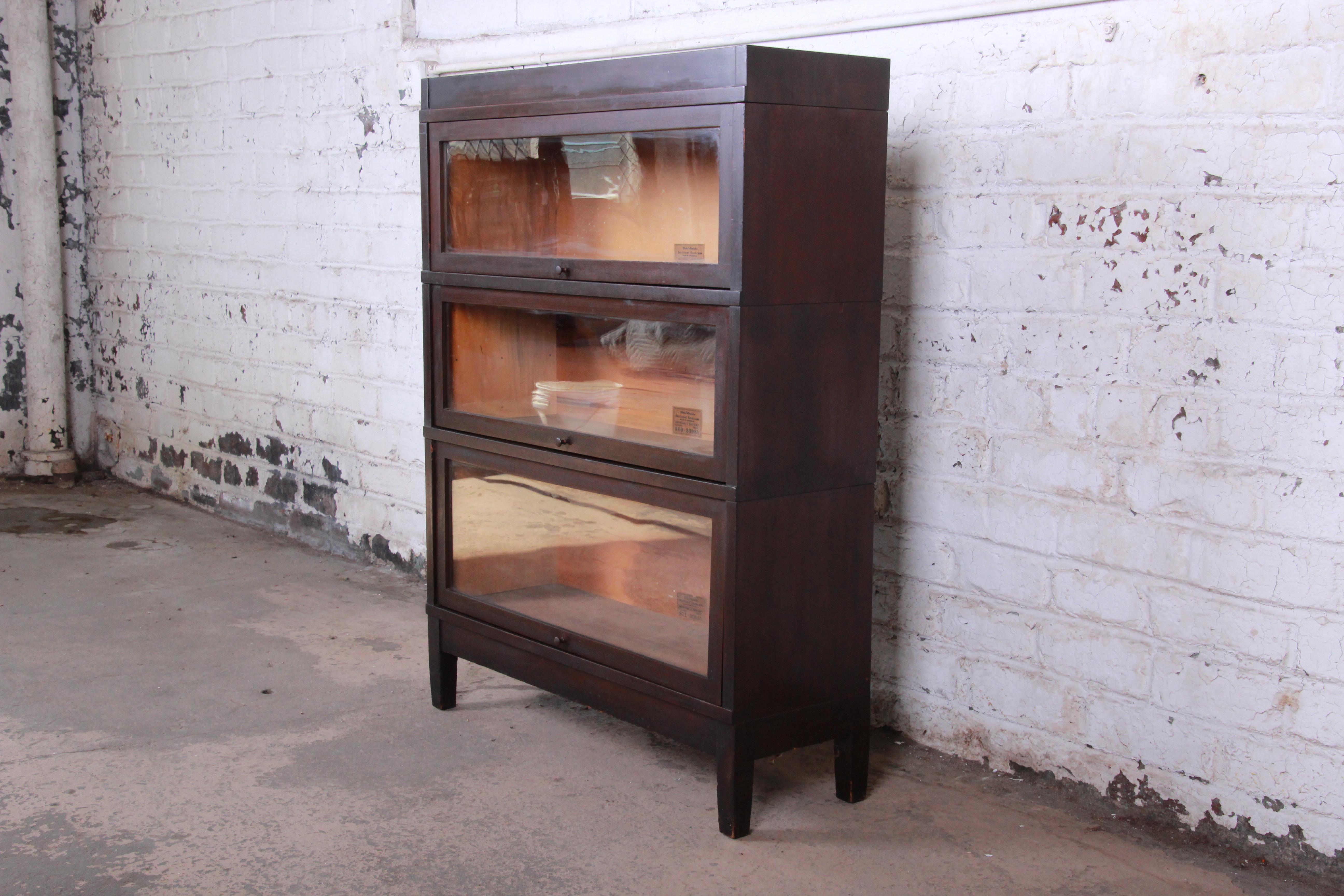 A very nice antique mahogany three-stack barrister bookcase by Globe-Wernicke. The bookcase has a beautiful mahogany finish. Each glass front door opens and closes smoothly and has plenty of room for storage. It comes apart in five sections,