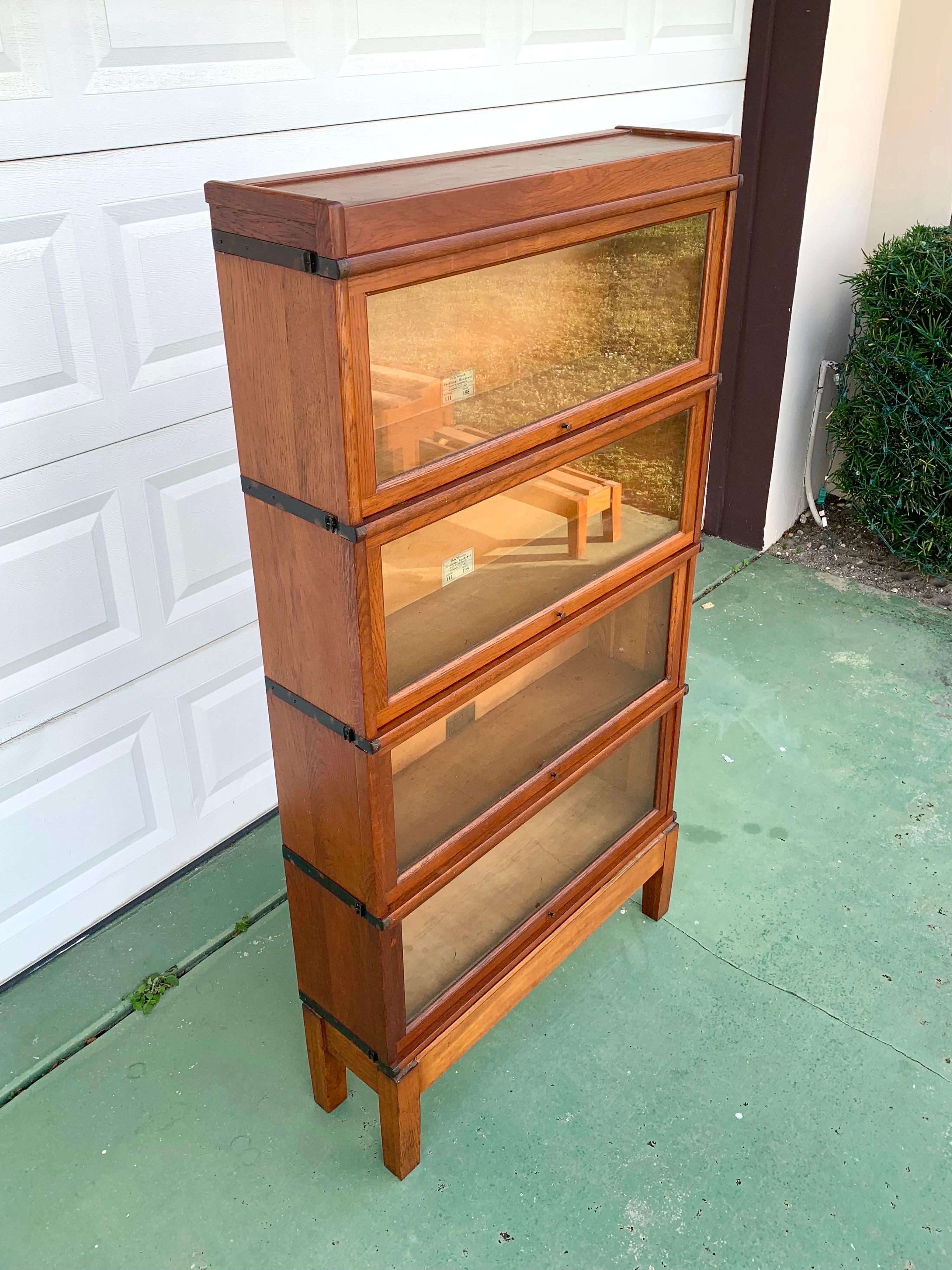 A gorgeous antique Arts & Crafts style four-stack barrister bookcase. 

Manufactured by Globe Wernicke

Made in Cincinnati, USA. Circa 1900. 

Quarter dawn oak with brass hardware and glass drawer fronts. 

Measures 34” wide 11.5” deep and