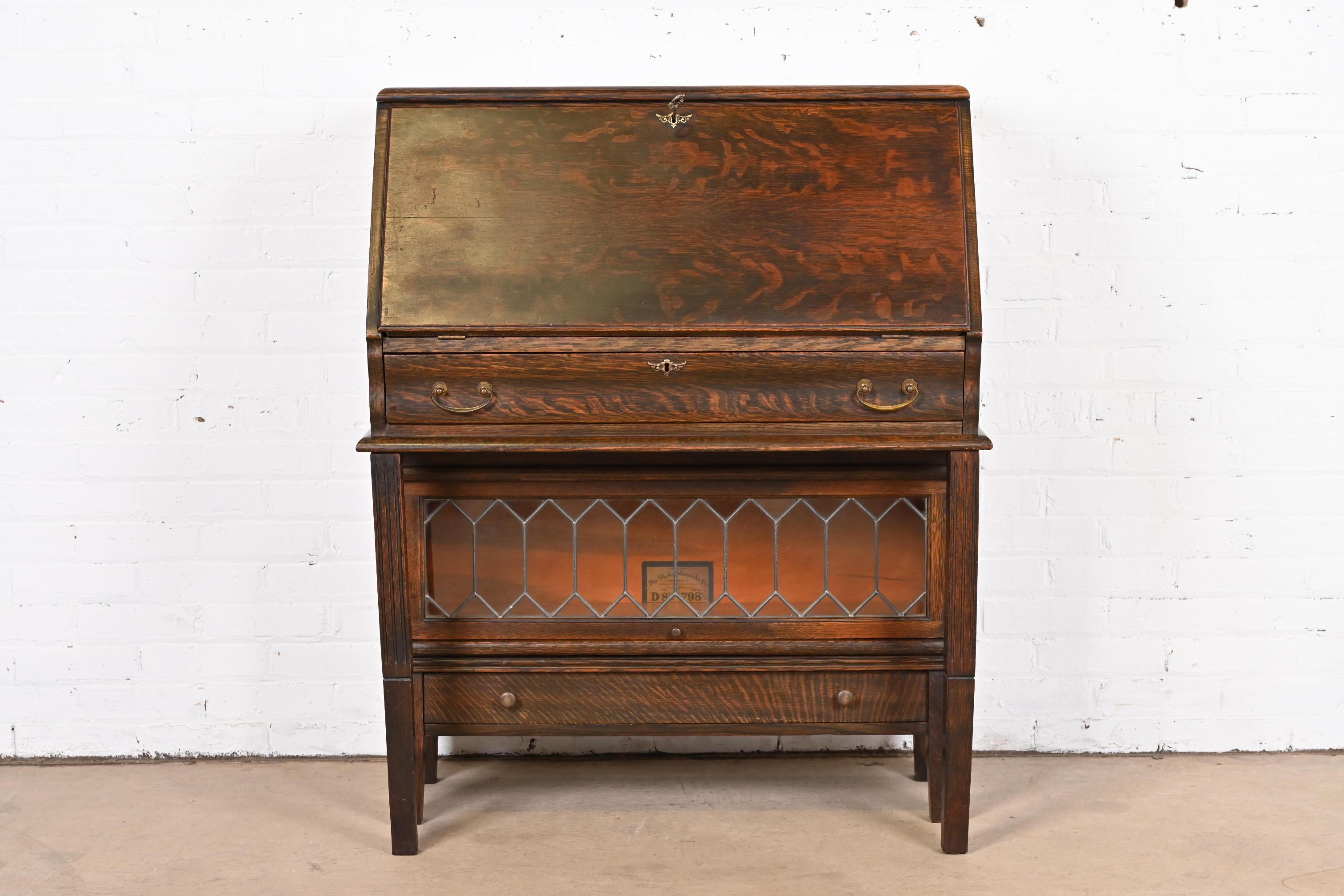 A rare antique Mission or Arts & Crafts drop front secretary desk with leaded glass barrister bookcase

By Globe Wernicke

USA, Circa 1920s

Quarter sawn oak, with original brass hardware and leaded glass door. Desk locks, and key is