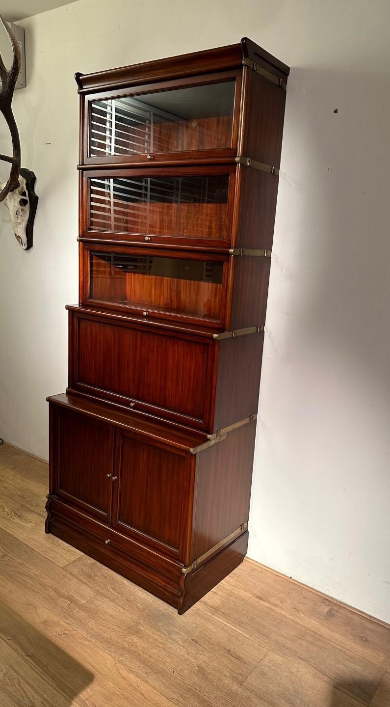 Mahogany Globe Wernicke Bookcase. This is a new cabinet (Showroom model)
Consisting of 5 stackable parts with drawer in plinth

Size: 86cm x 45cm x H. 208cm